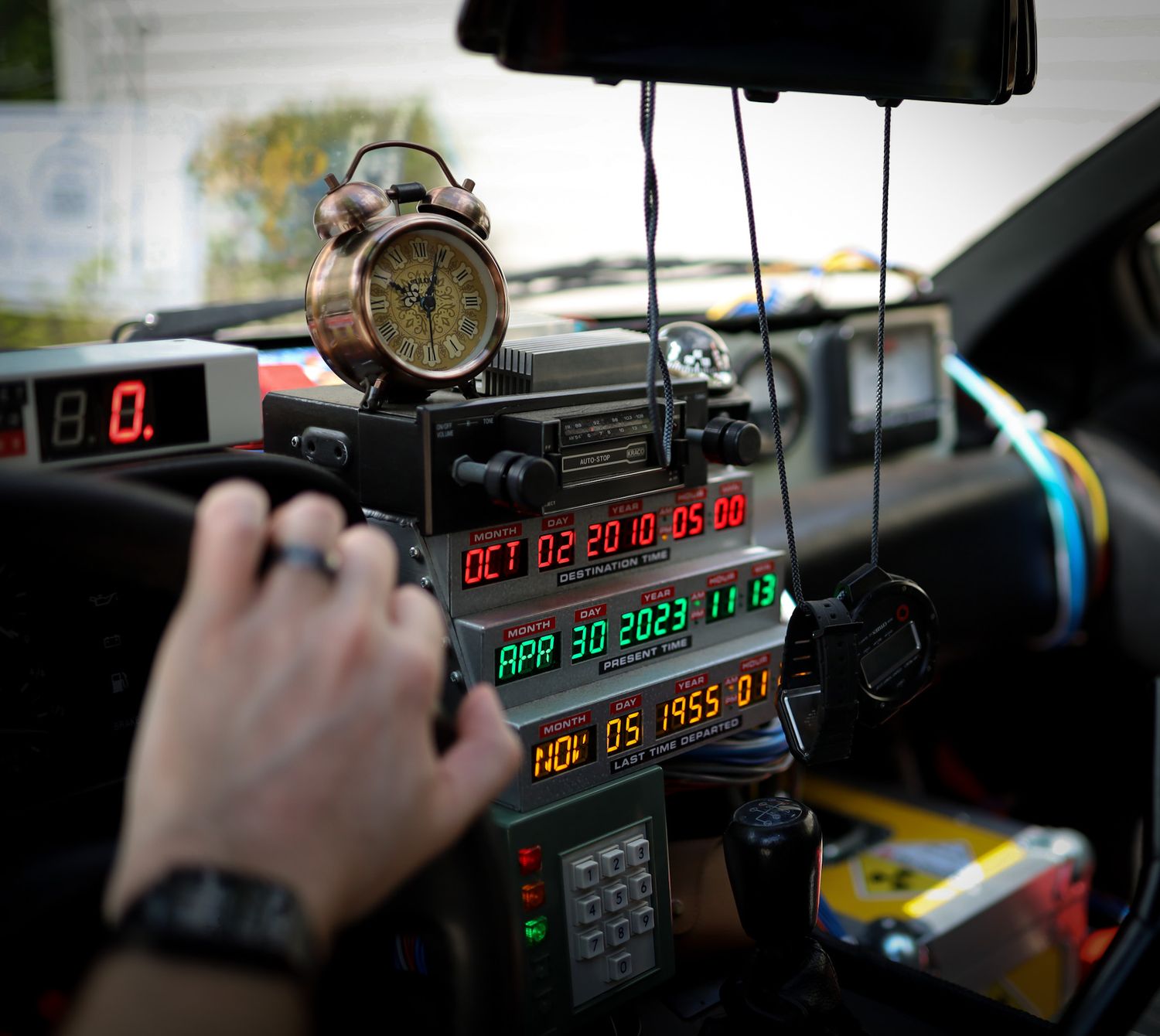 Back to the Future DeLorean time machine dashboard replica with flux capacitor display showing dates OCT 2010 and APR 2023.