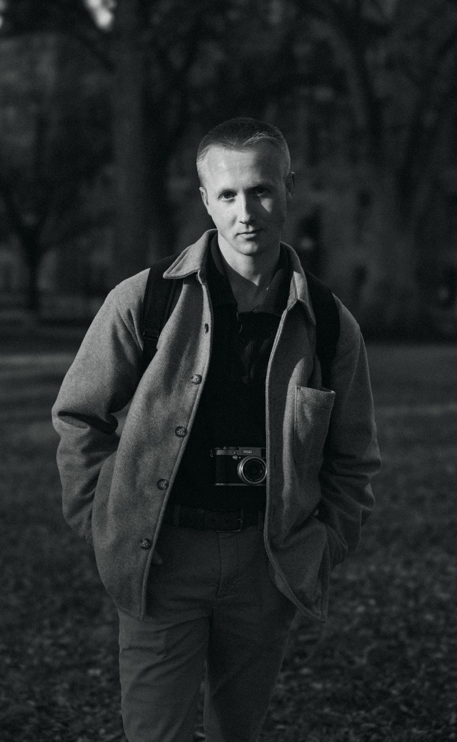 a black and white photo of a photographer at a city park