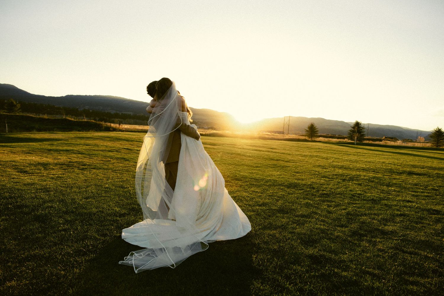 a documentary photo of a groom twirling his bride amongst the Idaho mountains after their ceremony as the sunsets