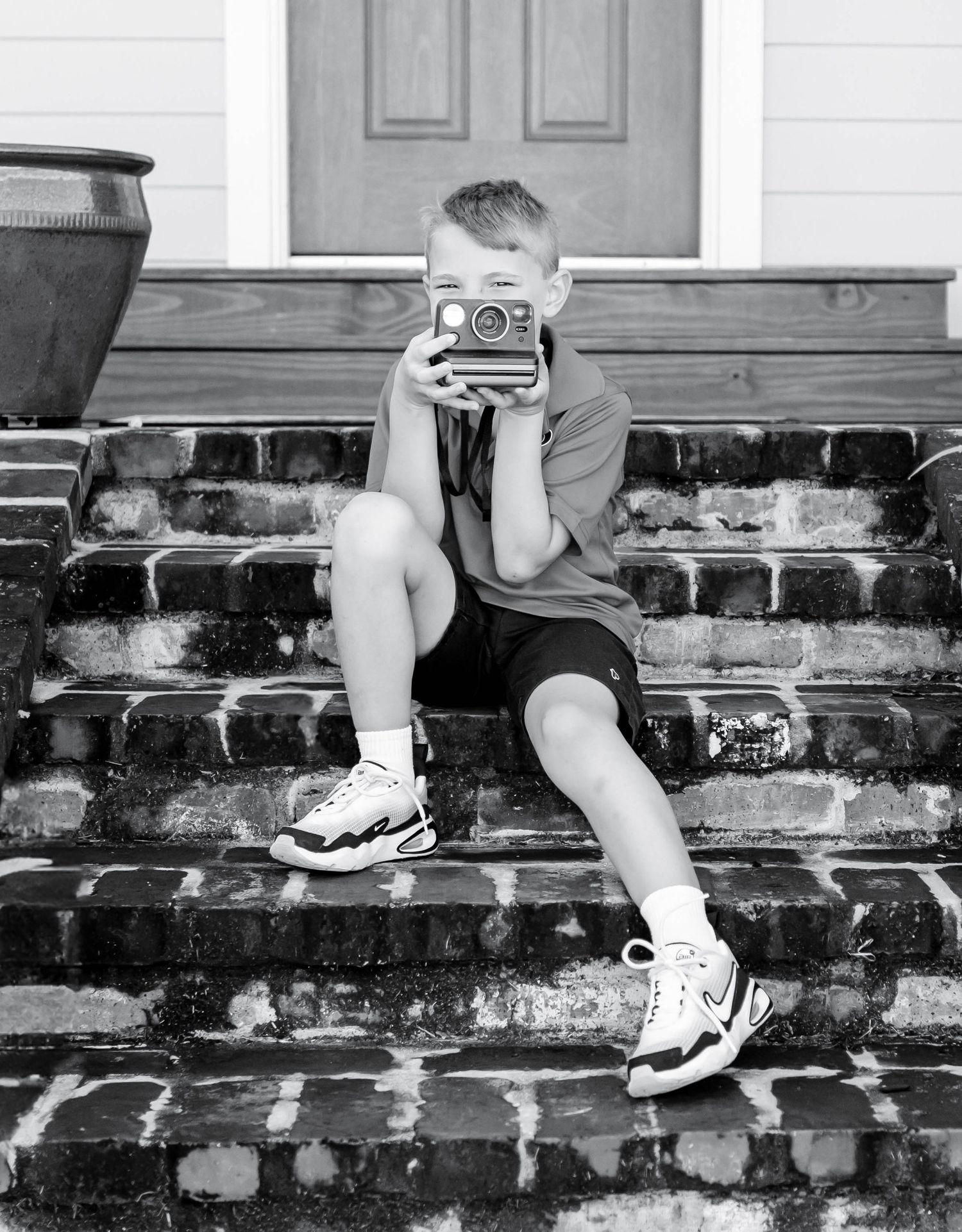 Back-to-school portrait of a young boy in Baton Rouge, sitting on his front porch — natural, timeless photography capturing childhood moment