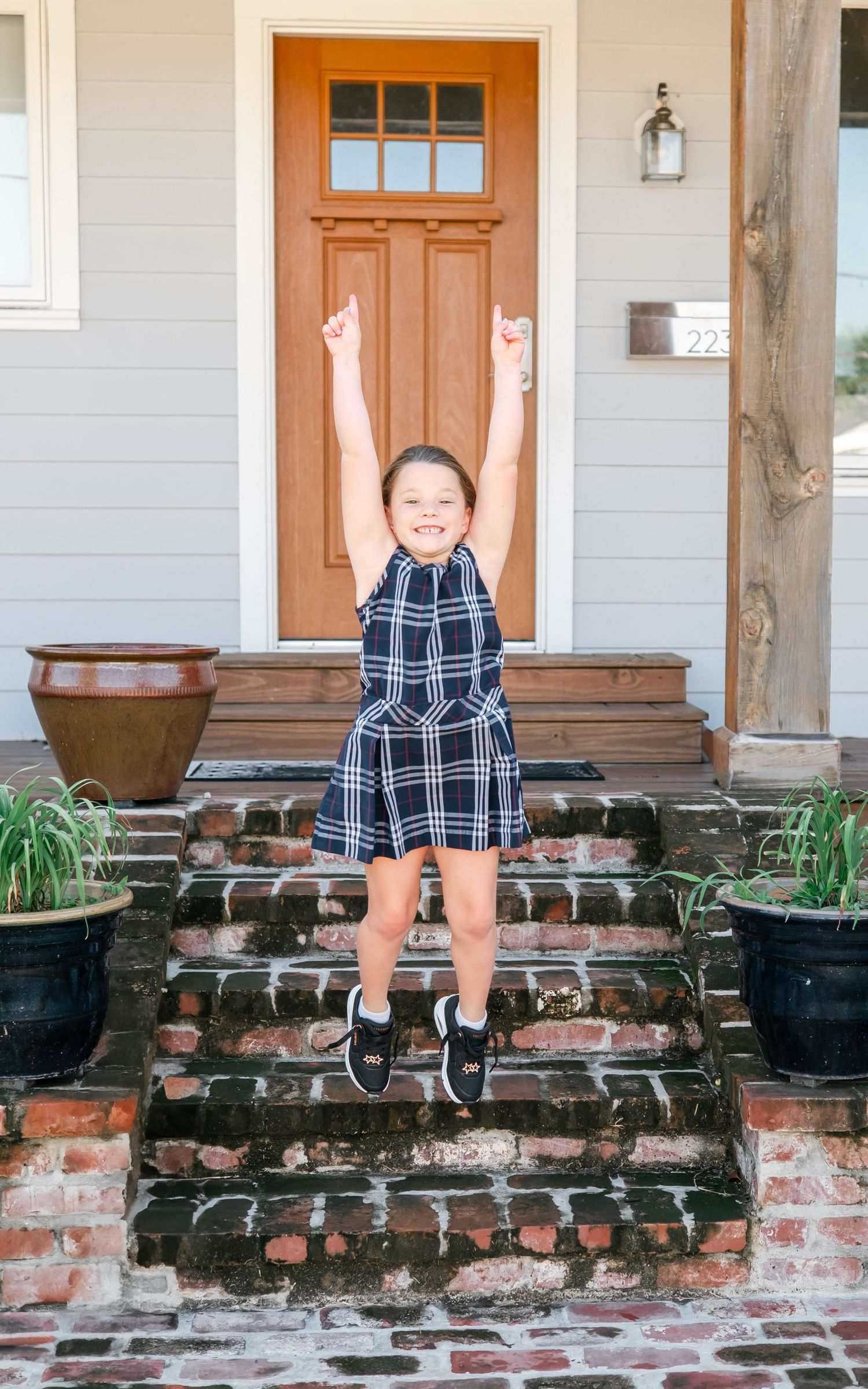 Three sequential photos show someone sitting on a brick porch ledge in various poses while wearing a plaid outfit.