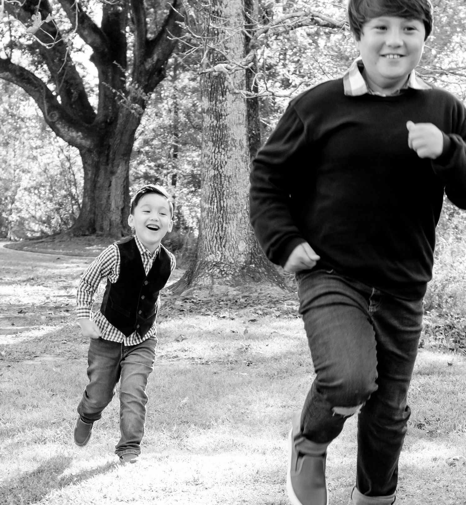 Black and white photo sequence showing joyful movement and play in an outdoor setting among trees.