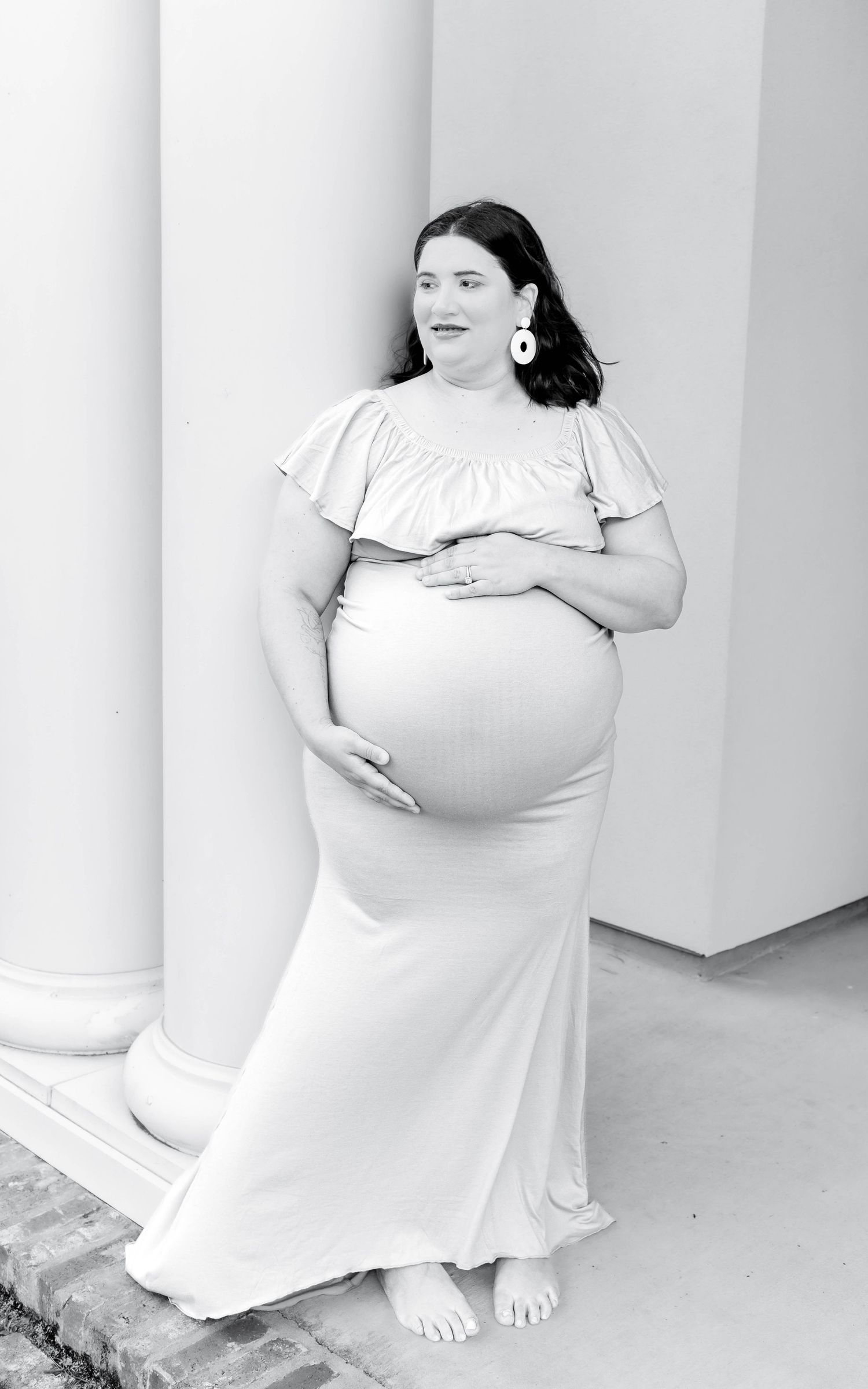 A person wearing a white t-shirt poses against a white wall in a minimalist artistic photo series.
