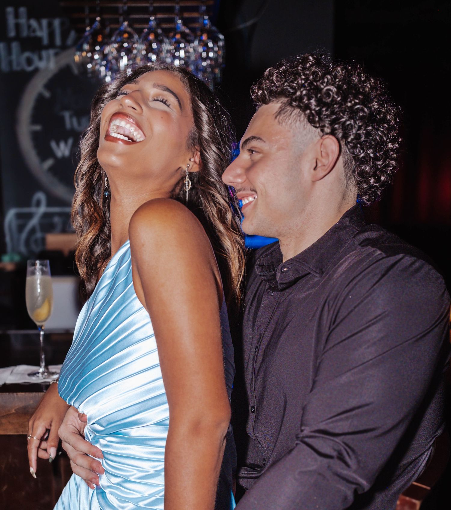 Two people share an intimate moment at what appears to be a party or event venue.