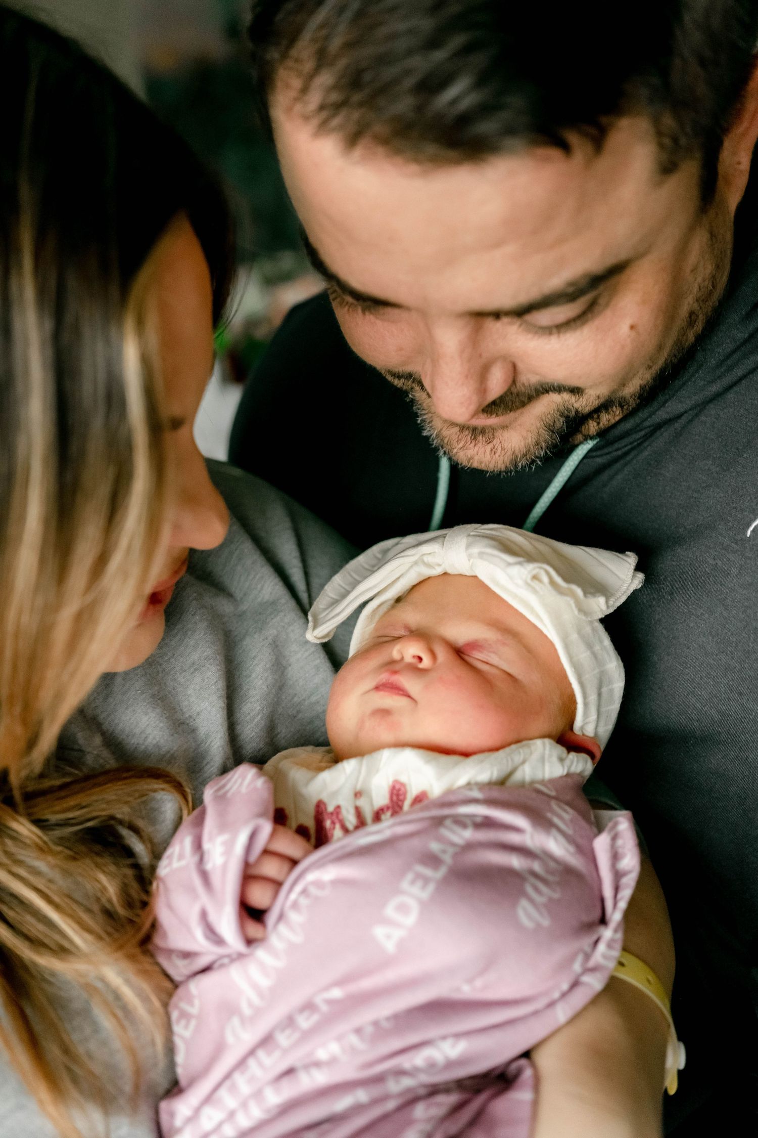Tender portrait of new parents holding their newborn daughter—capturing love, connection, and the beauty of those first precious moments.