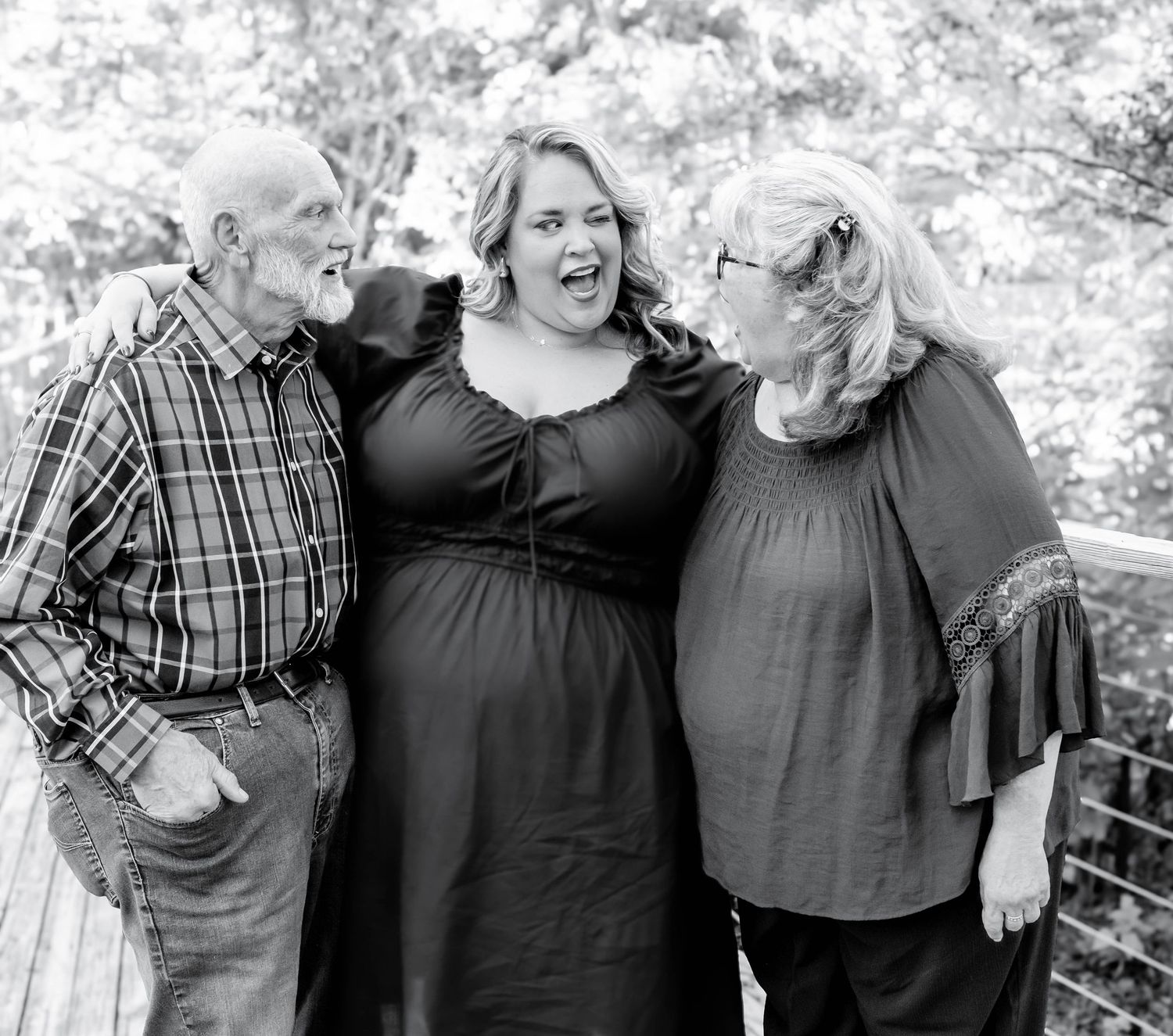 A black and white photo series shows people embracing and laughing together outdoors in casual attire.
