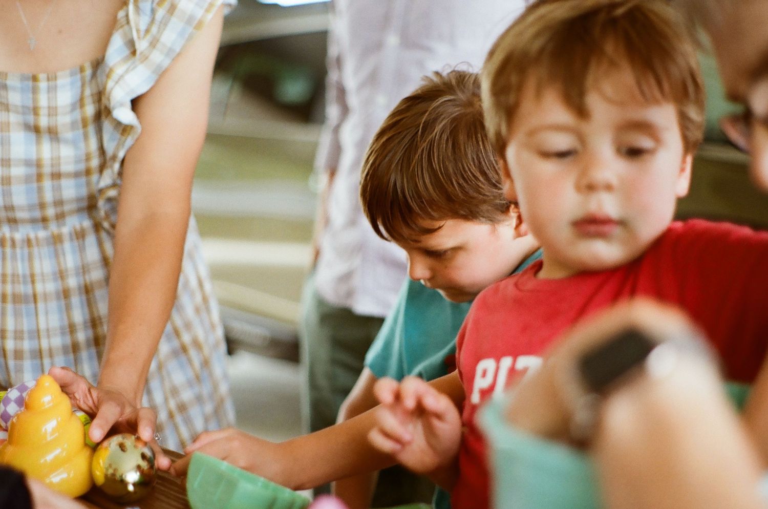 Children gathered around a table participating in an activity with colorful toys and materials.