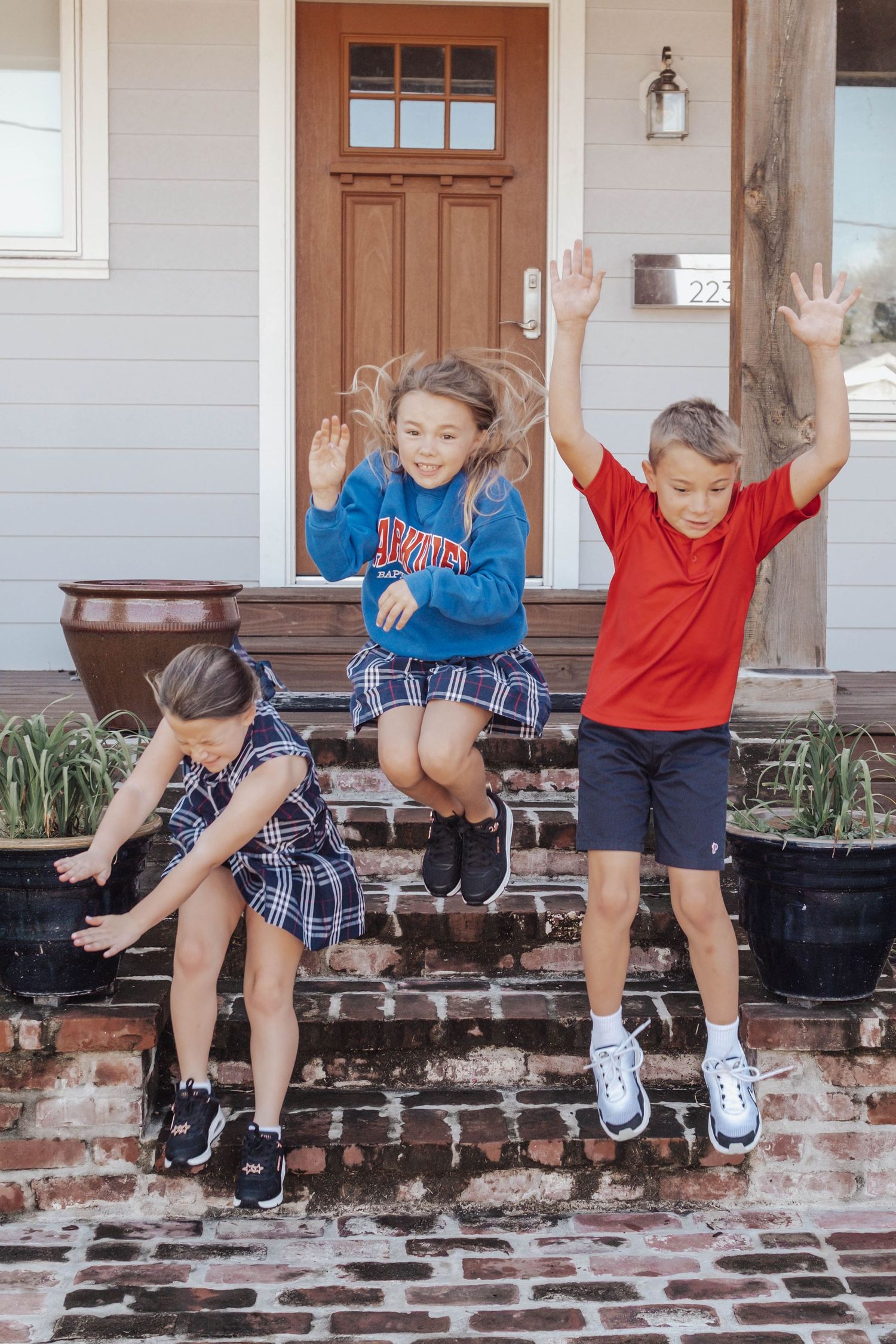 Series of photos showing children sitting and jumping off brick steps in front of a house.