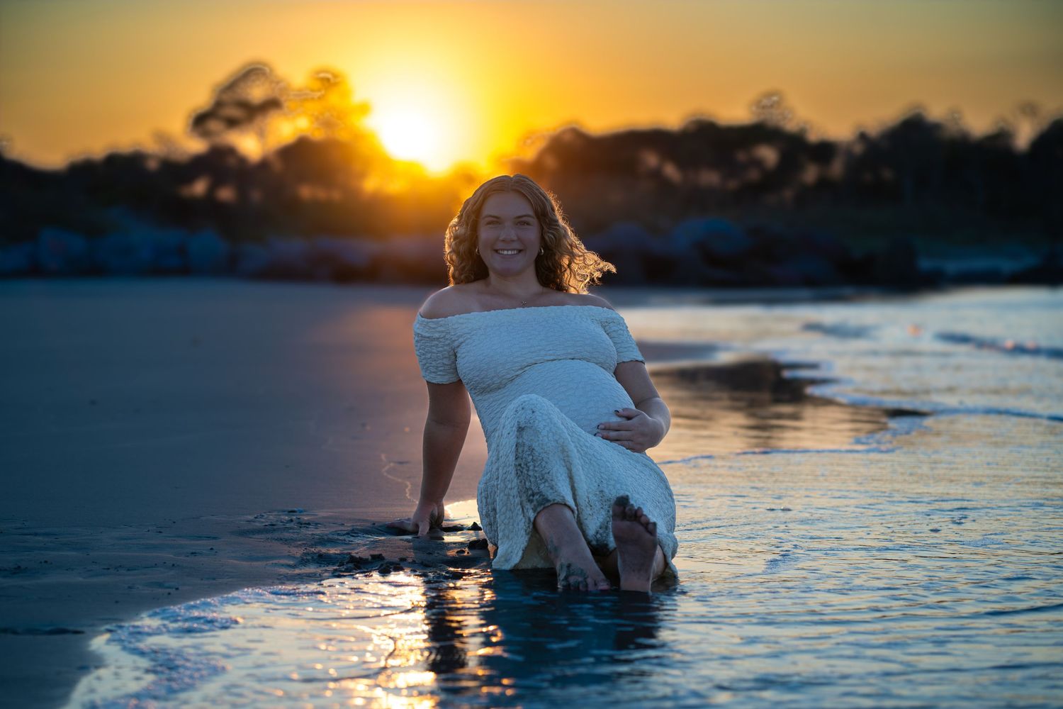Golden sunset over water with silhouettes creating romantic beach scene.