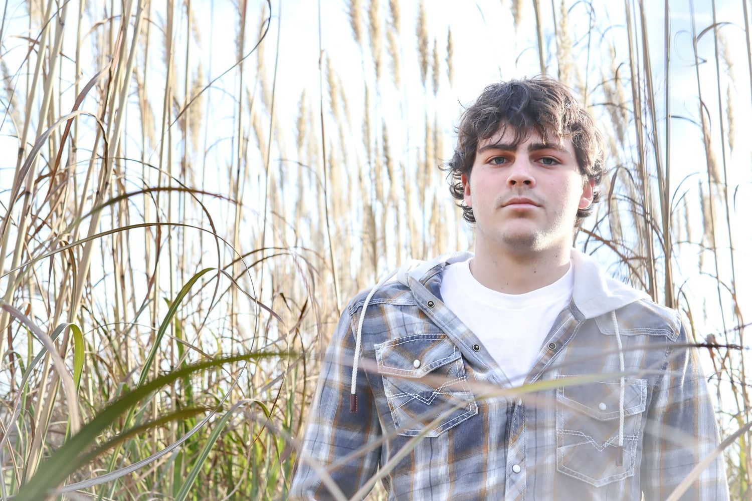 Person in plaid shirt overlooking scenic winter woodland landscape.