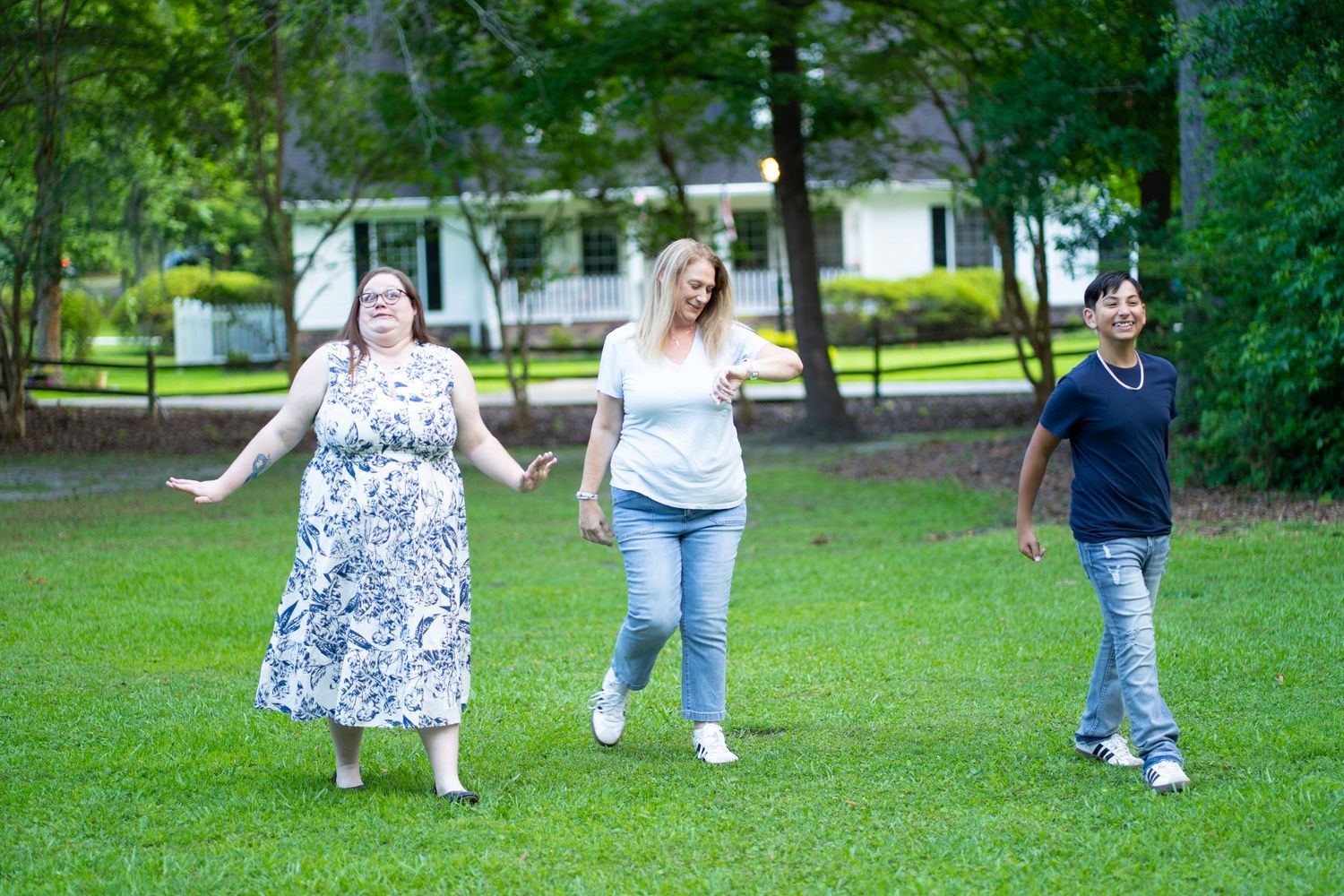 People walking together in a lush green park setting on a sunny day.