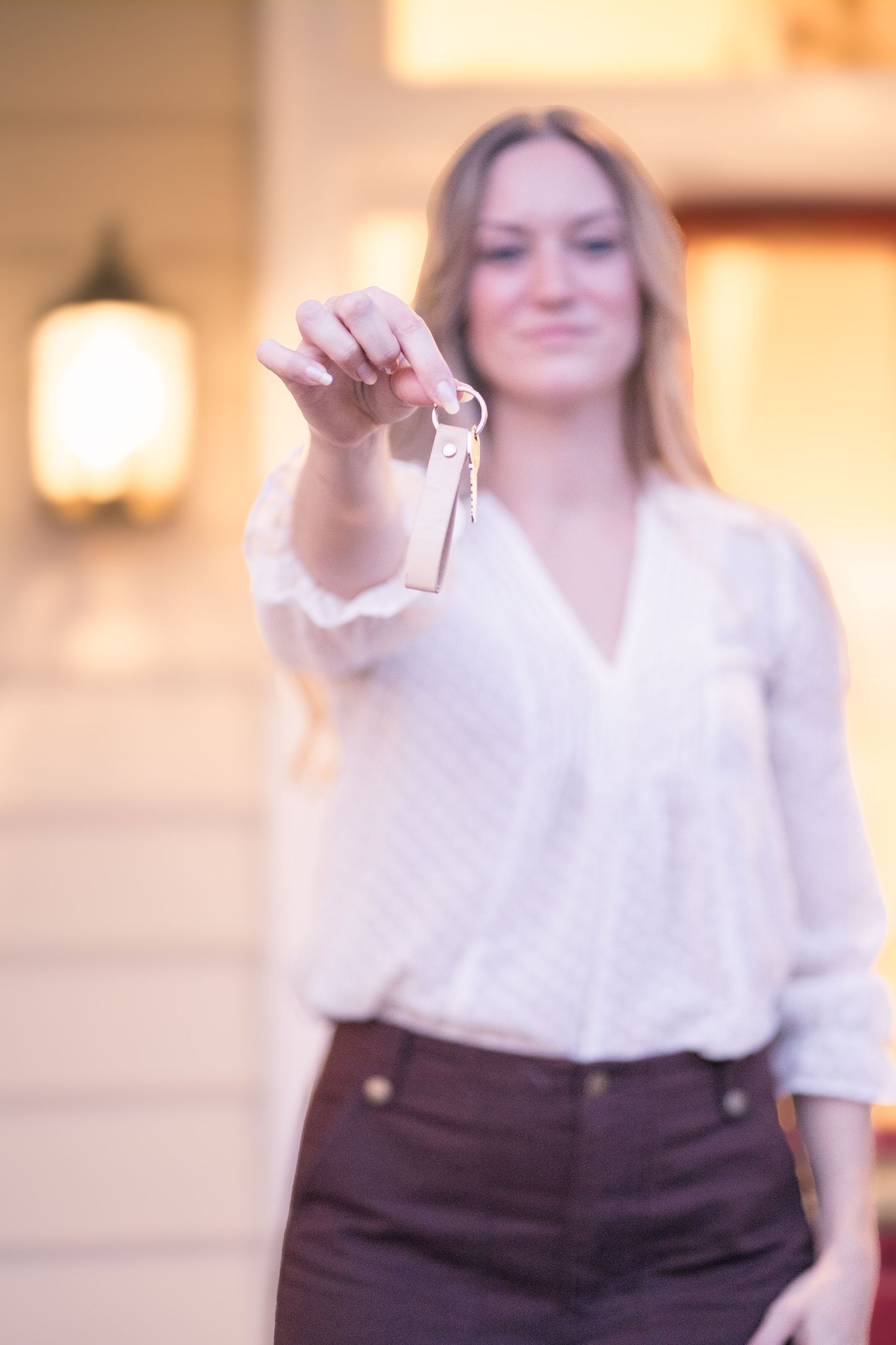 Professional woman in business attire poses confidently in outdoor setting with warm lighting.