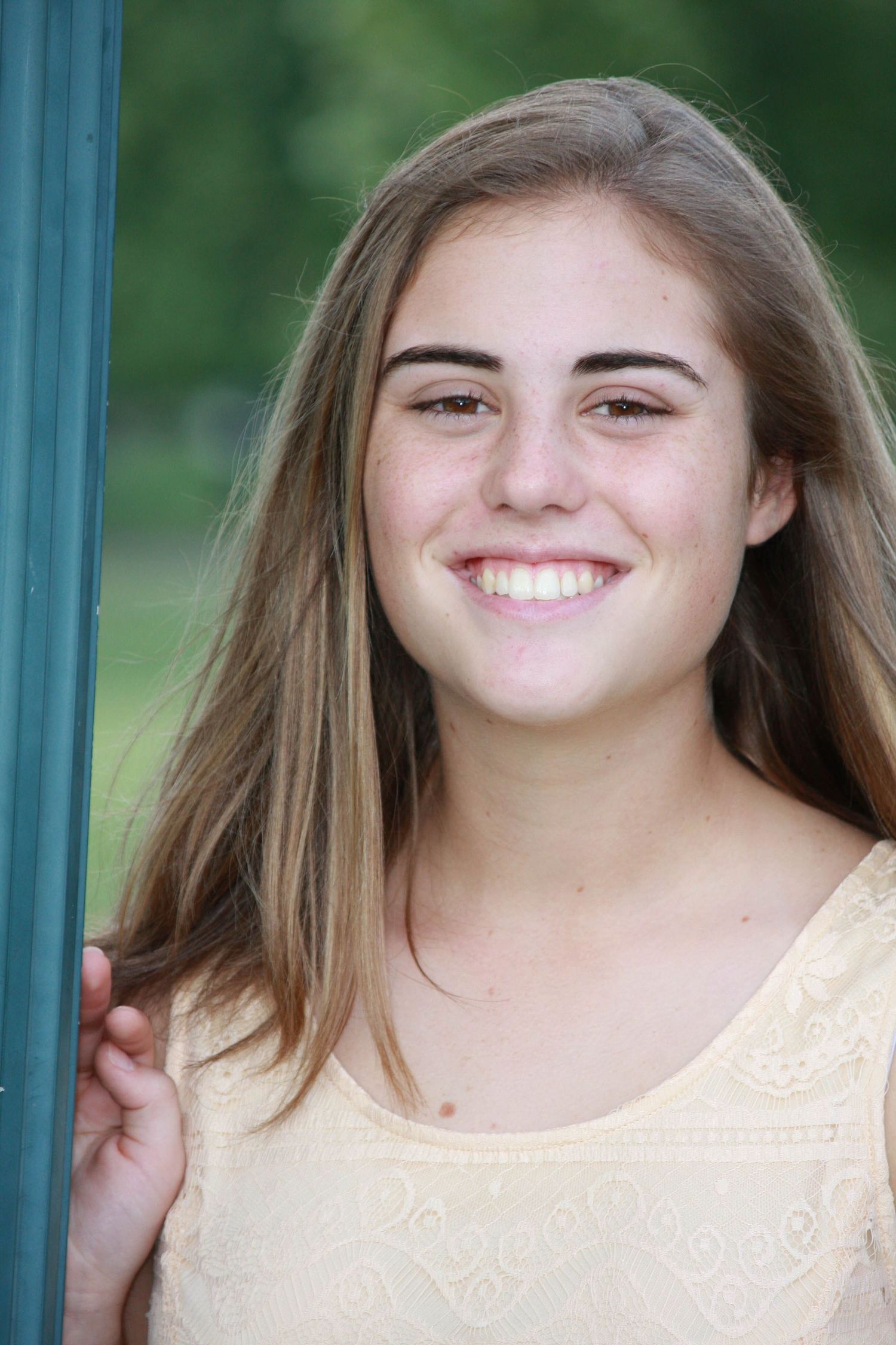 Portrait against green background showcasing bright genuine smile.