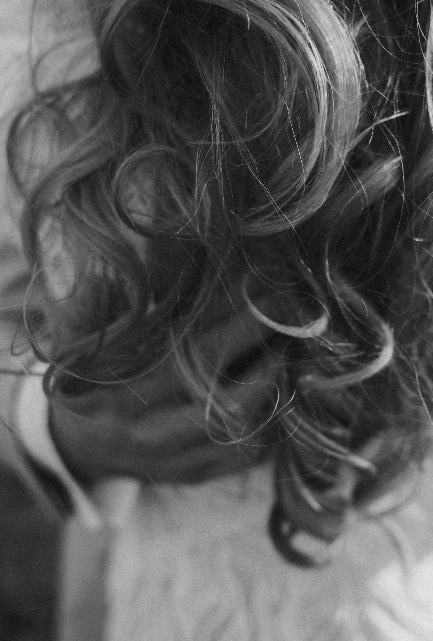 A series of black and white close-up photographs showing curly hair details and texture in artistic composition.