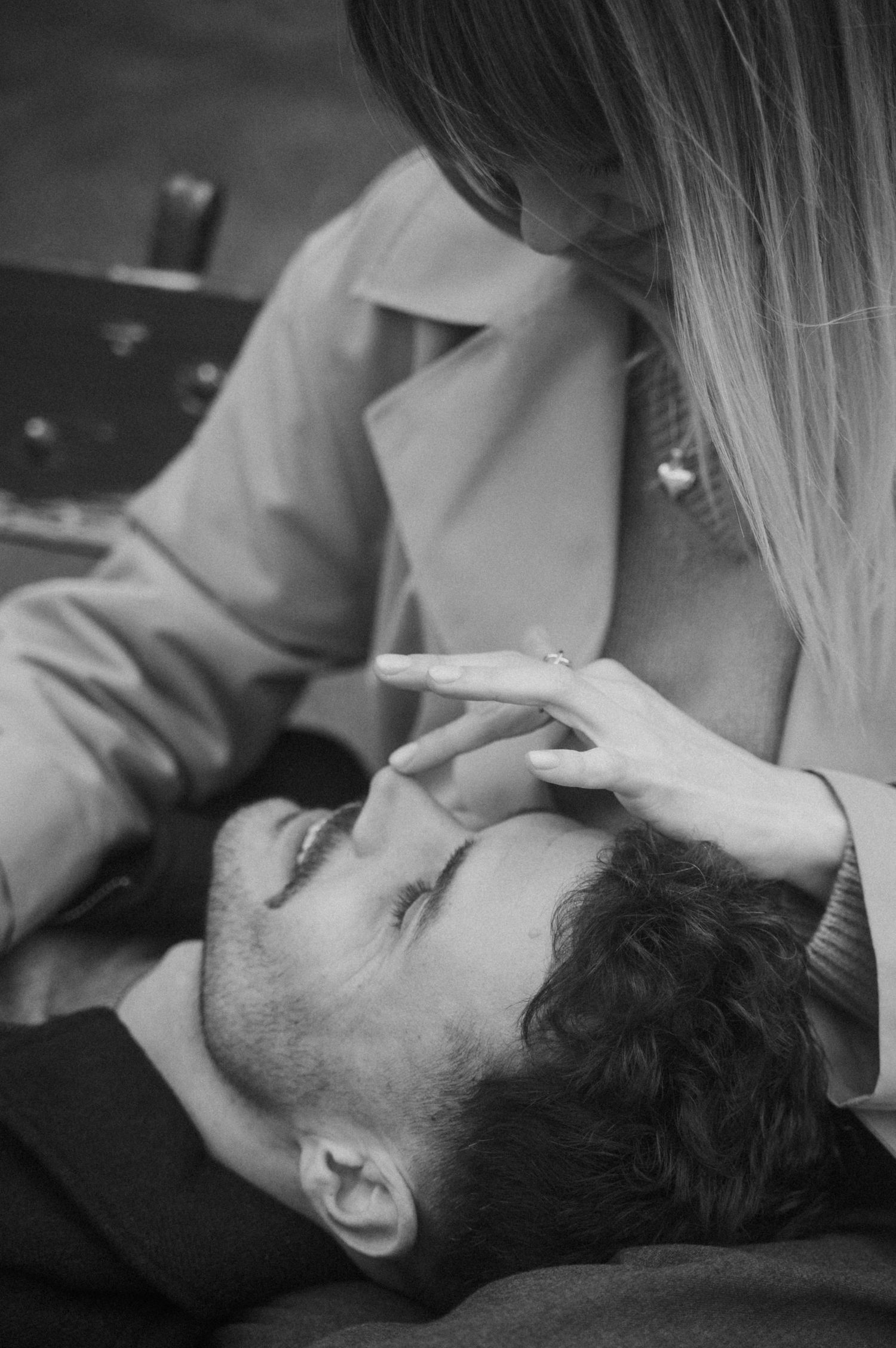 A black and white version of a couple sharing an intimate moment outdoors with gentle interaction.