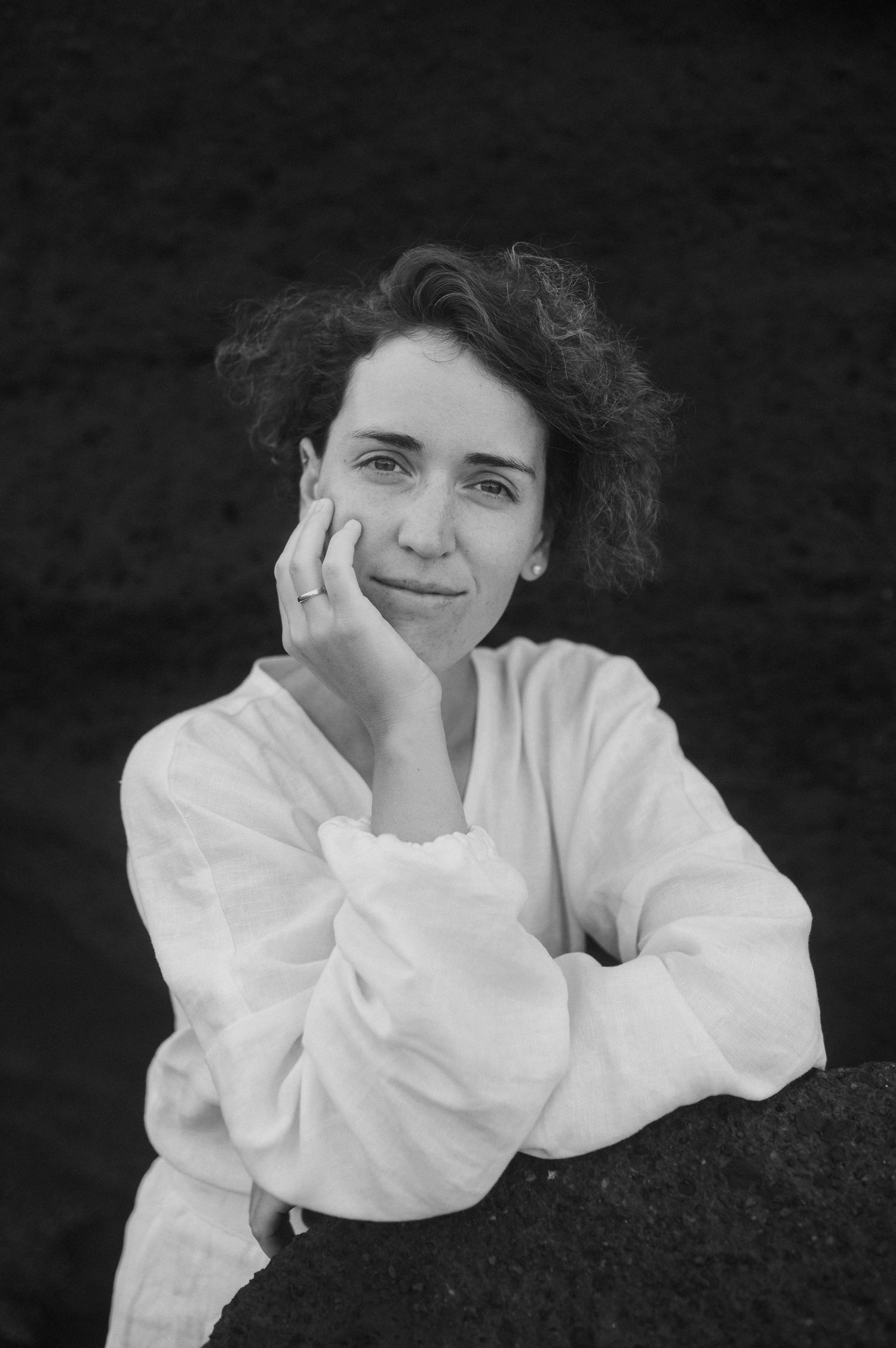 A series of black and white portrait photos showing someone in a white shirt resting their head on their hand.