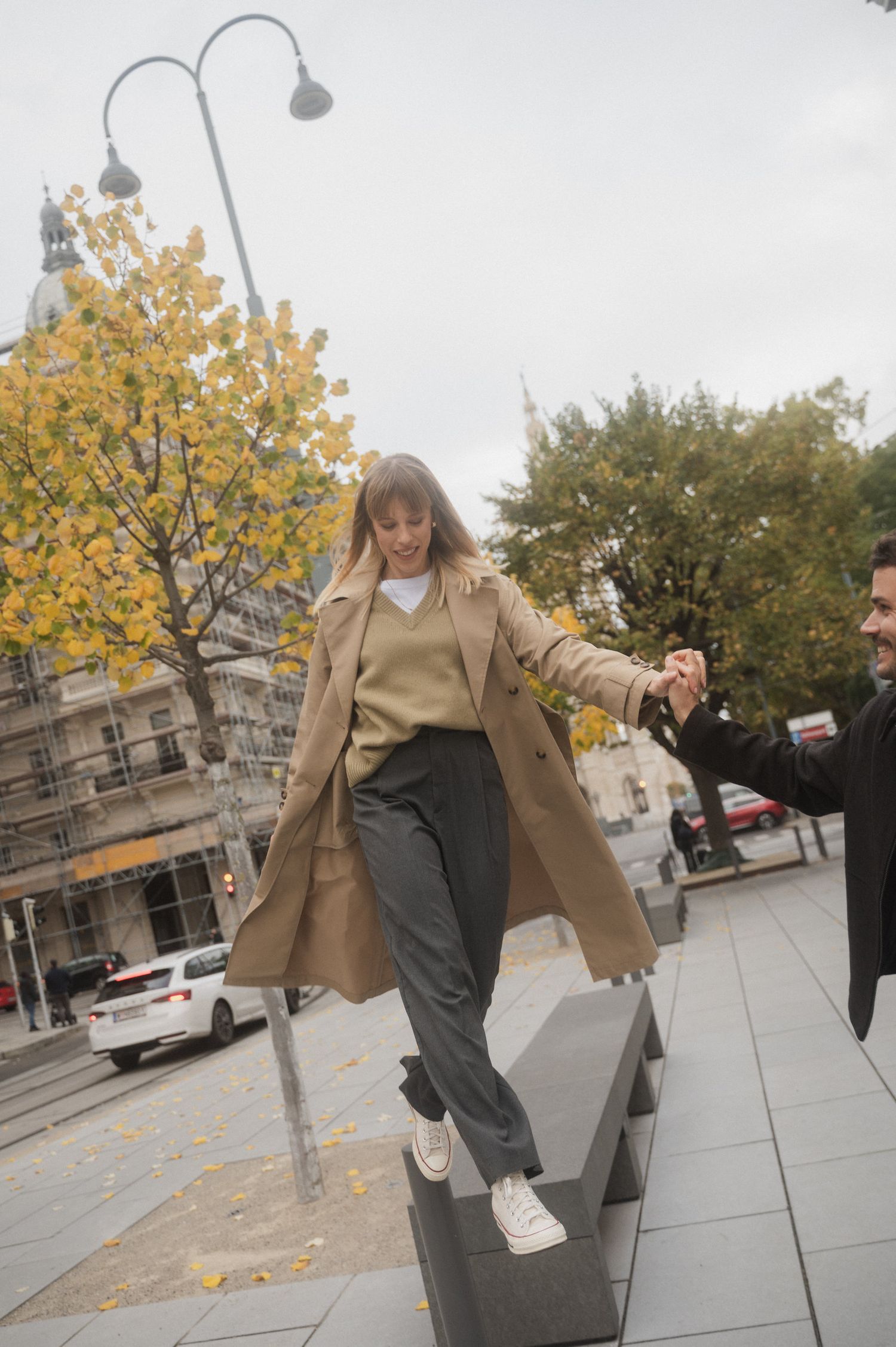 A series of five photos showing someone in a beige blazer and gray pants posing casually on an autumn sidewalk.