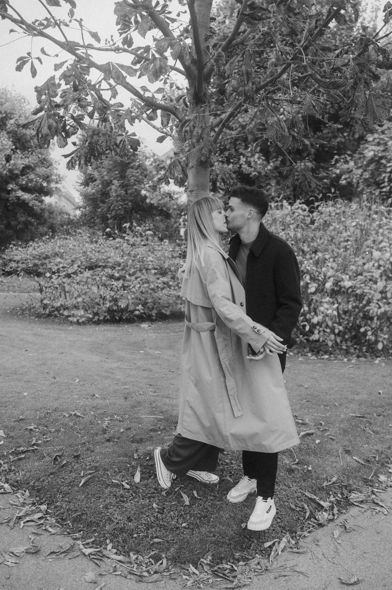 Series of black and white photos showing a couple dancing together on grass near trees and foliage.