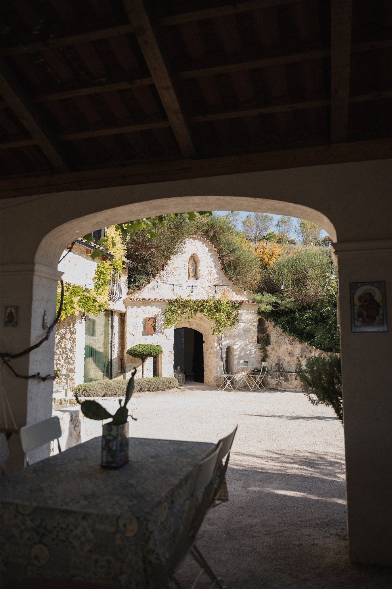 Stone archway entrance to a rustic Mediterranean-style courtyard.