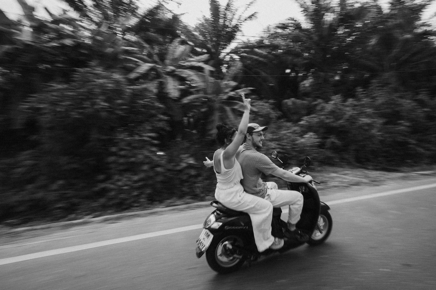 Newlyweds riding away on a motorcycle in a creative motion blur shot.