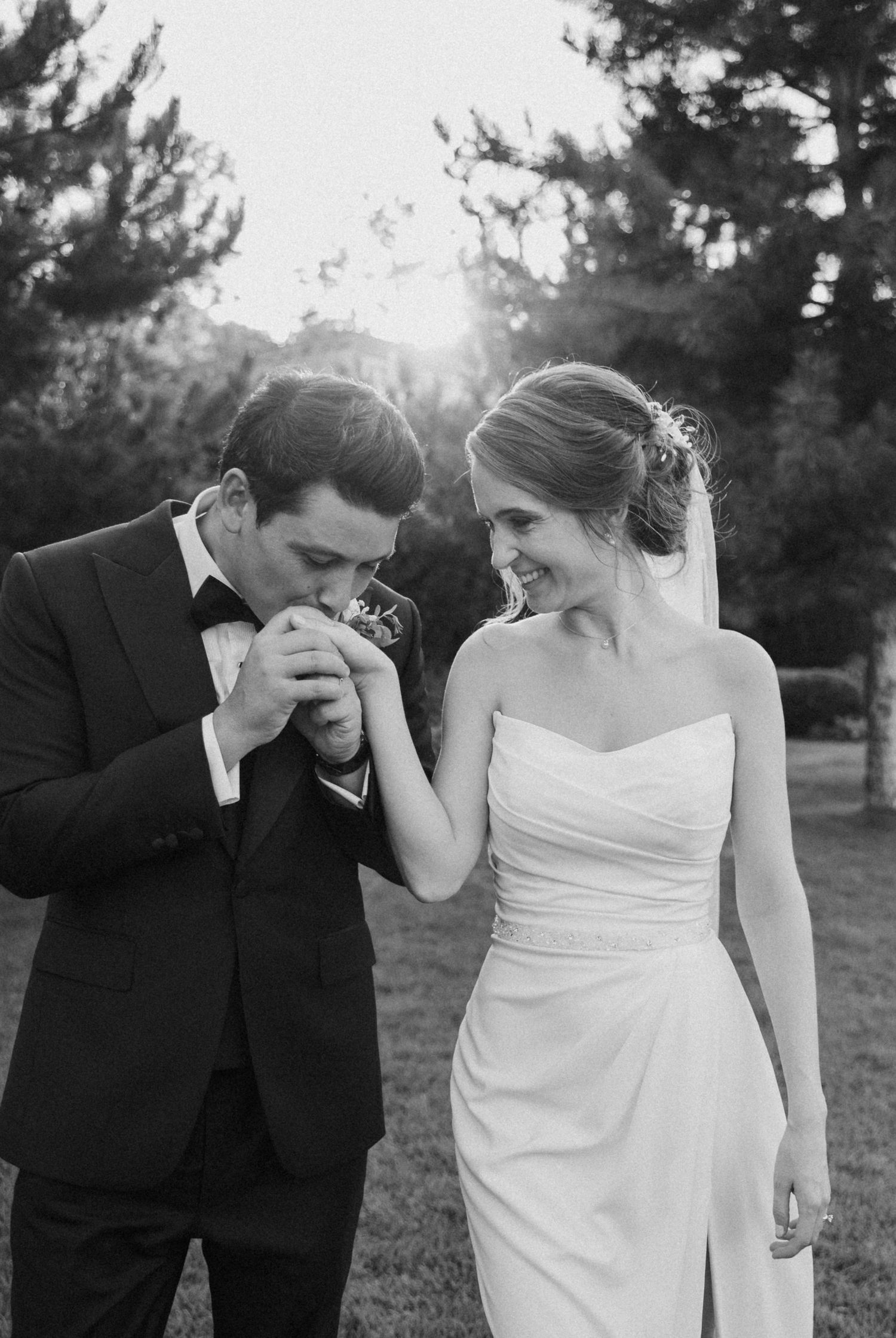 Candid black and white sequence shows newlyweds sharing laughs and tender moments outdoors.