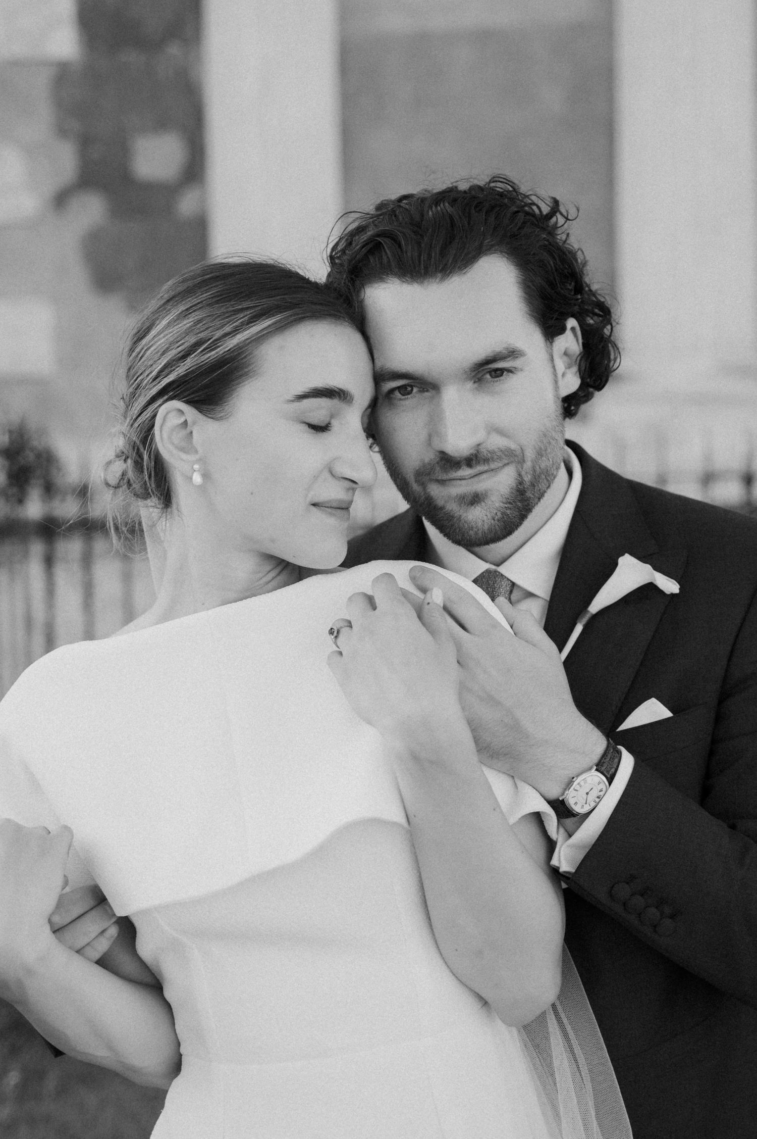 An intimate black and white portrait of a couple sharing a tender moment on their wedding day.