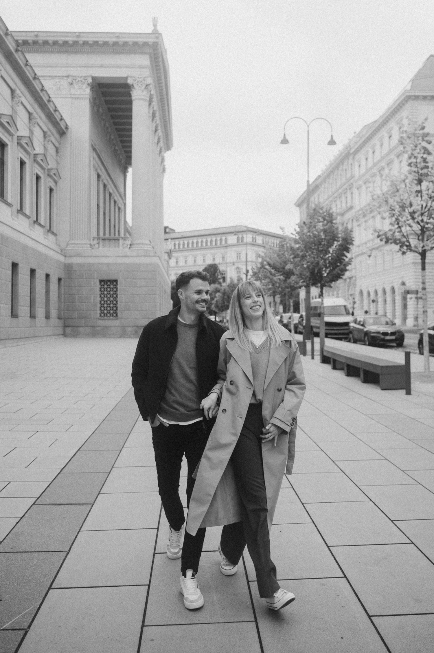 A series of black and white photos showing two people walking together on a paved urban sidewalk.