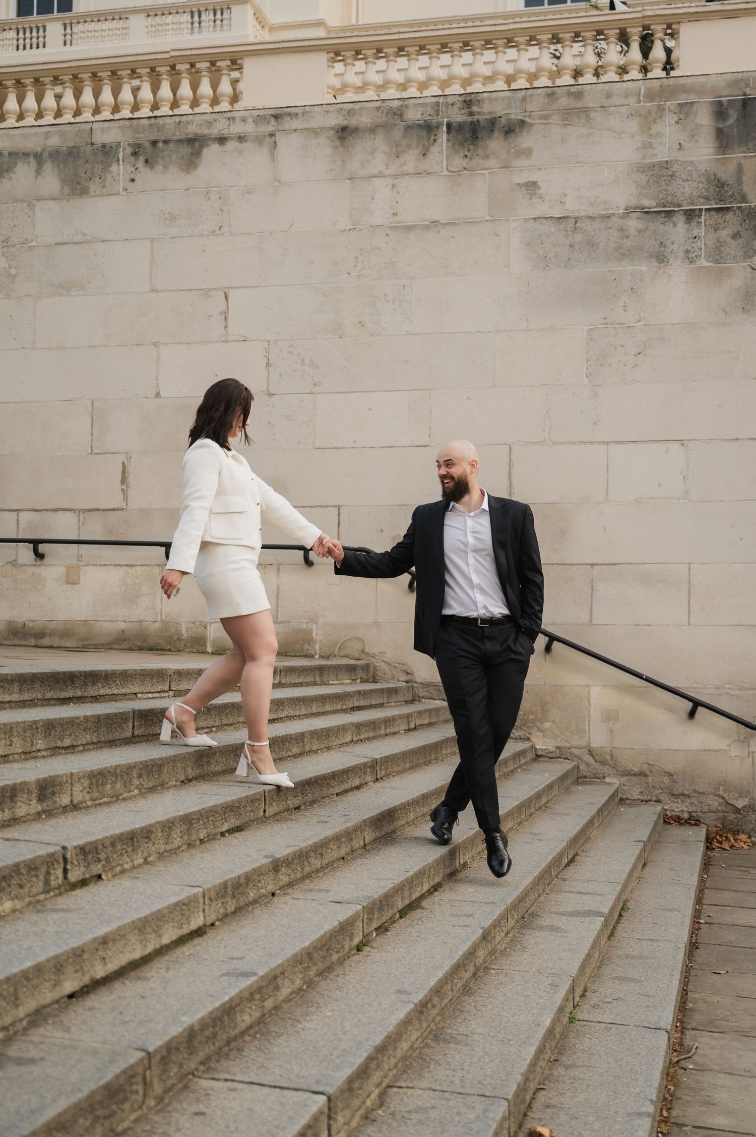 A sequence showing two people running up stone steps in an urban setting.