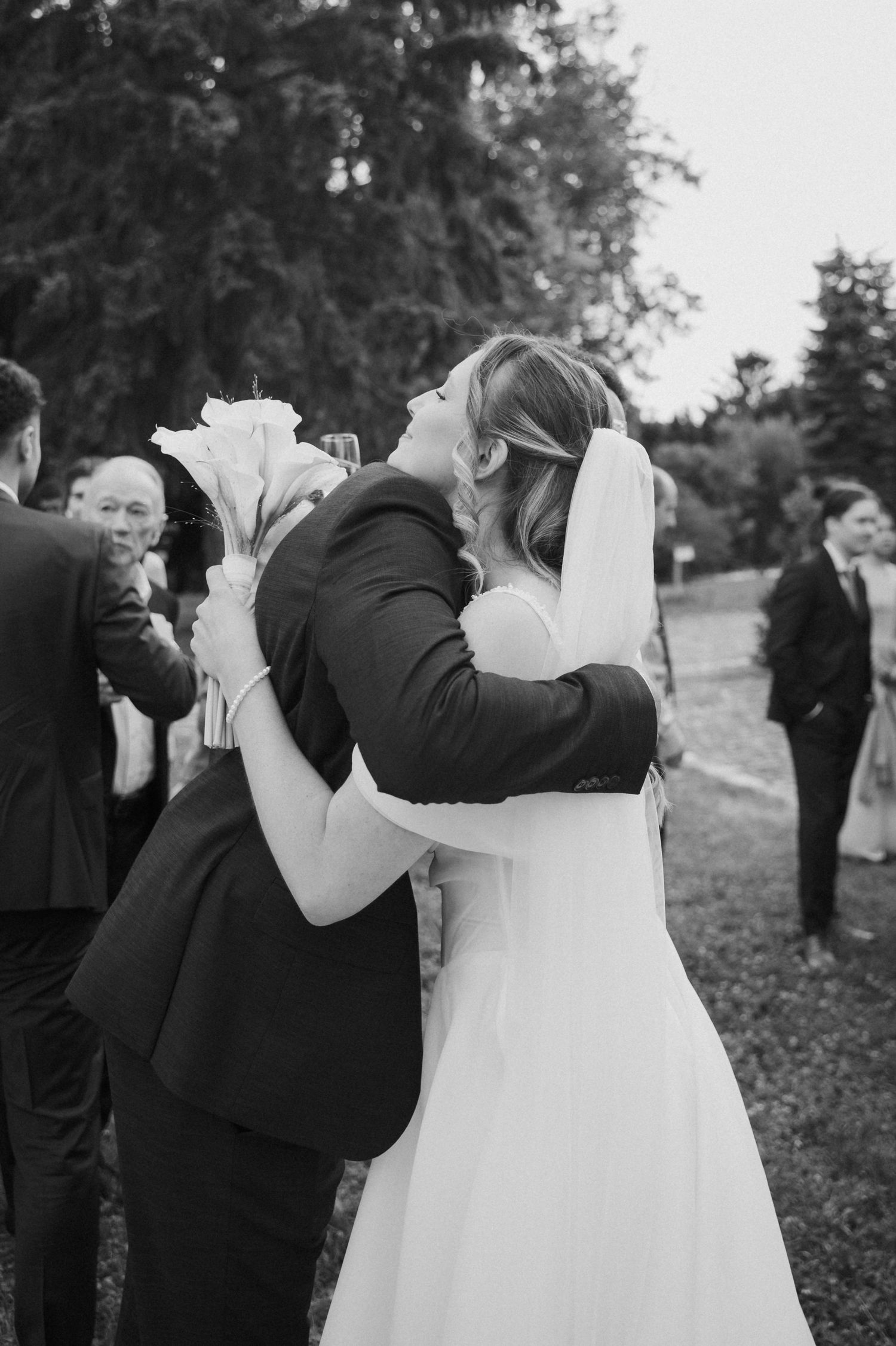 Black and white photo of bride and groom sharing an emotional embrace after the wedding ceremony.