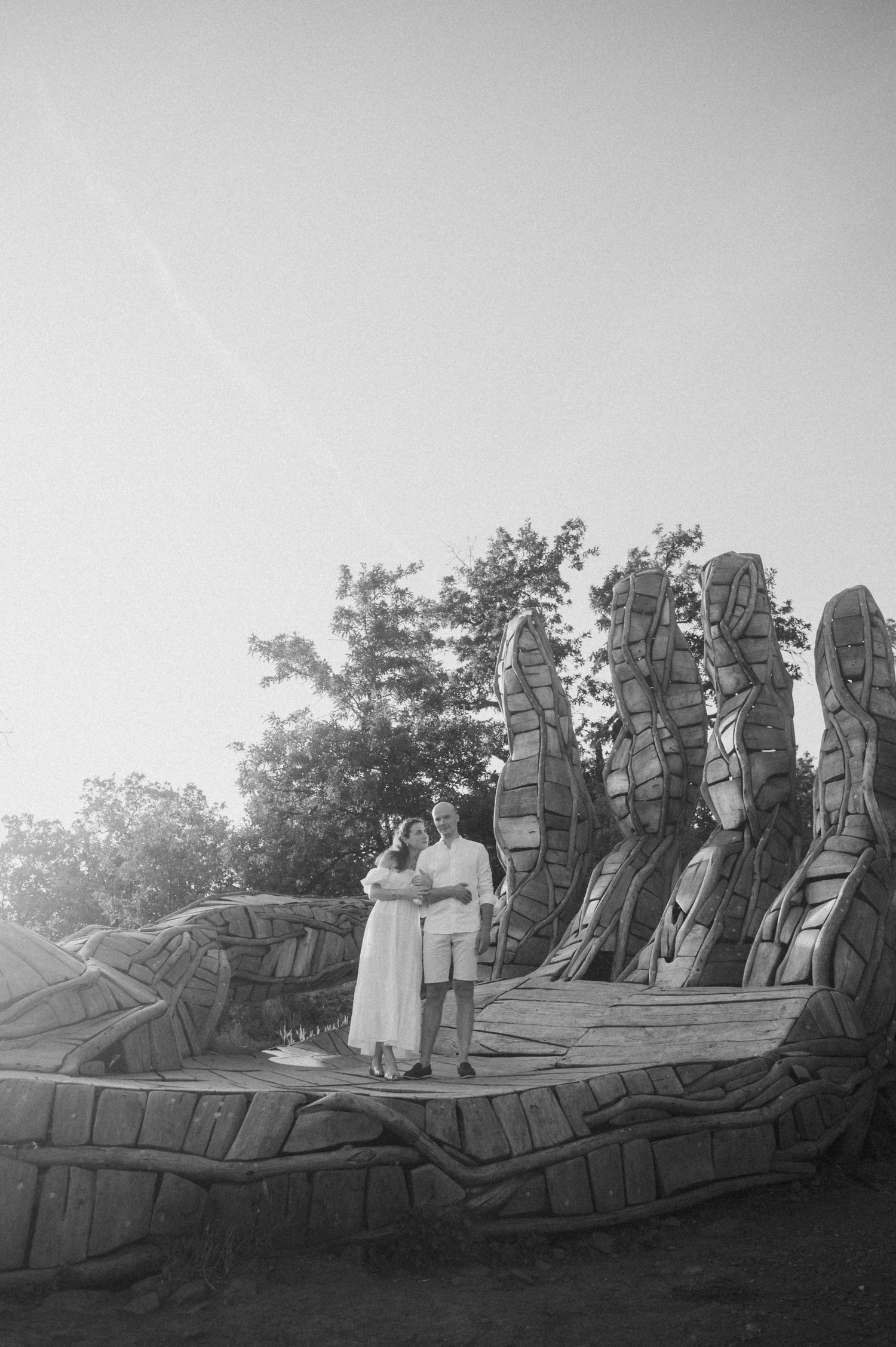 Black and white photo series showing Easter Island moai statues against a cloudy sky with trees in the background.