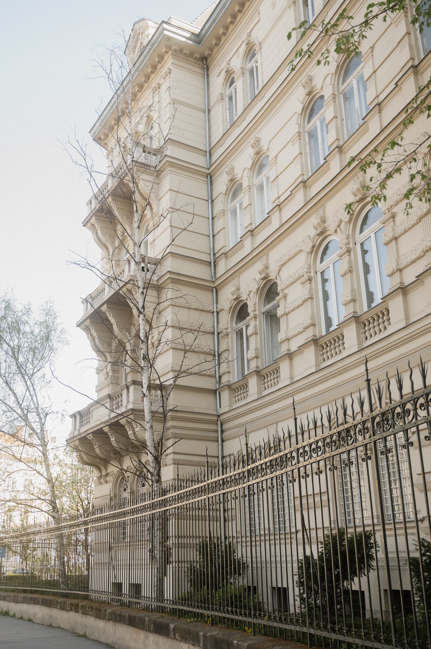 Elegant white Victorian townhouse with ornate architectural details and black iron fence viewed from multiple angles.
