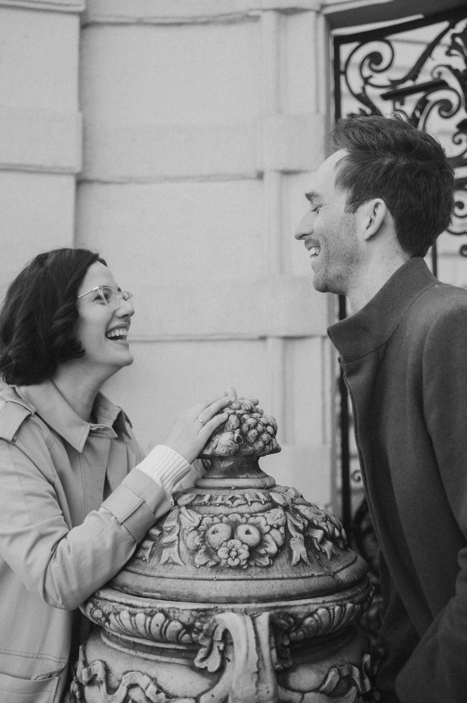 A series of vintage black and white photos showing a couple laughing and interacting near an ornate architectural detail.