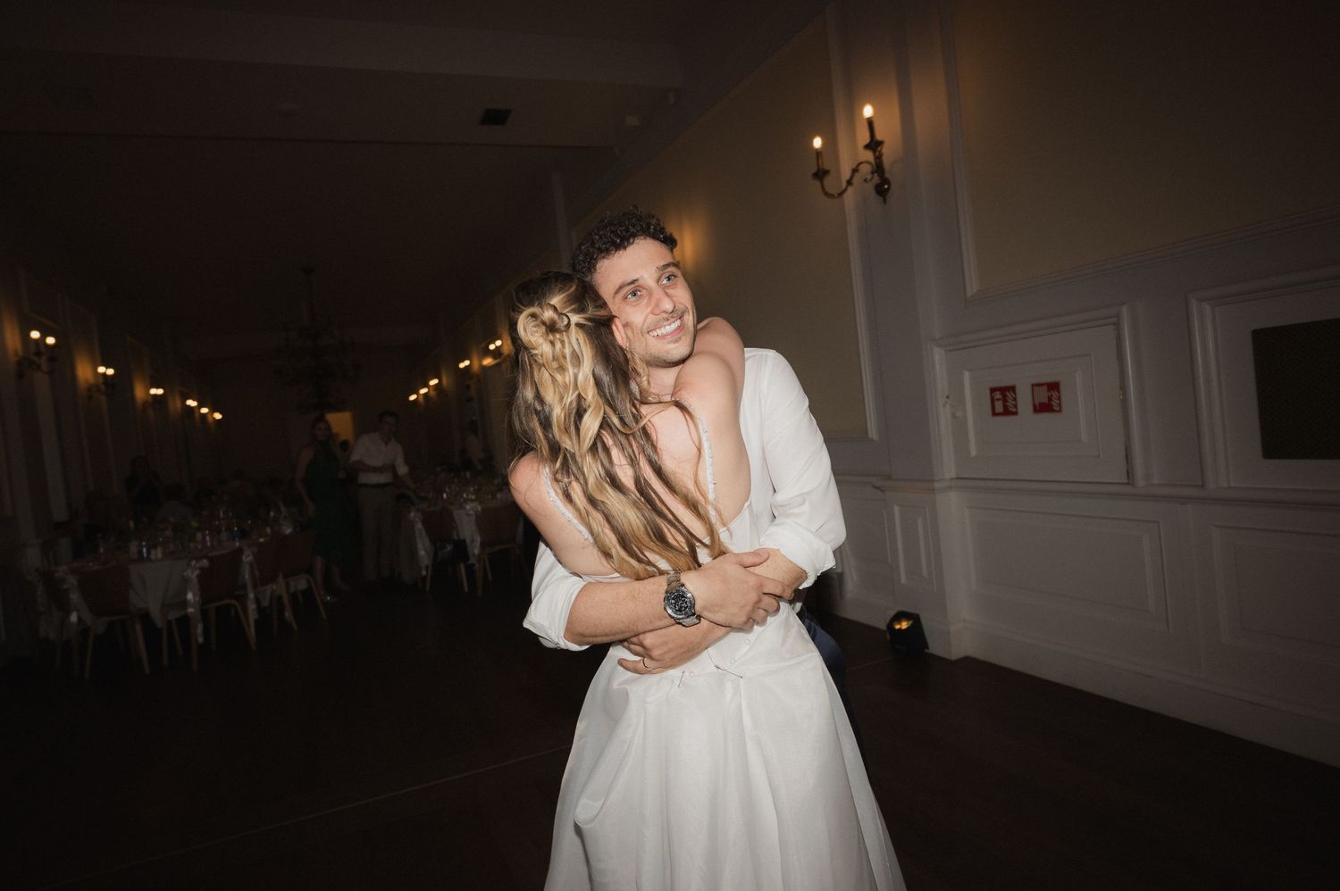 Groom joyfully lifting and spinning bride on the dance floor at their wedding reception.