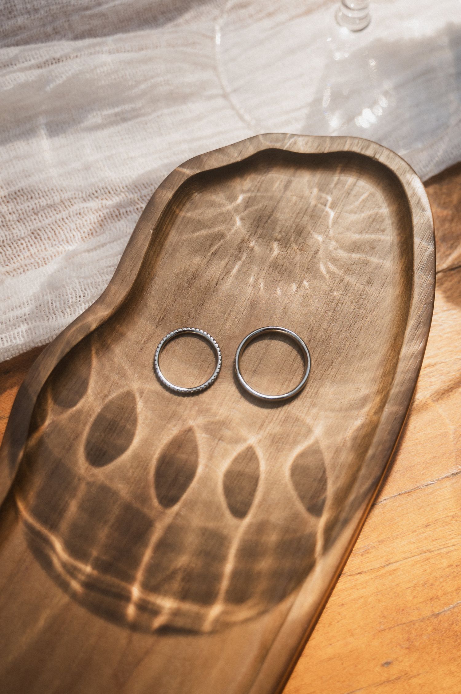 Light patterns cast shadows on a wooden serving tray with two horseshoe decorations creating a smiley face design.