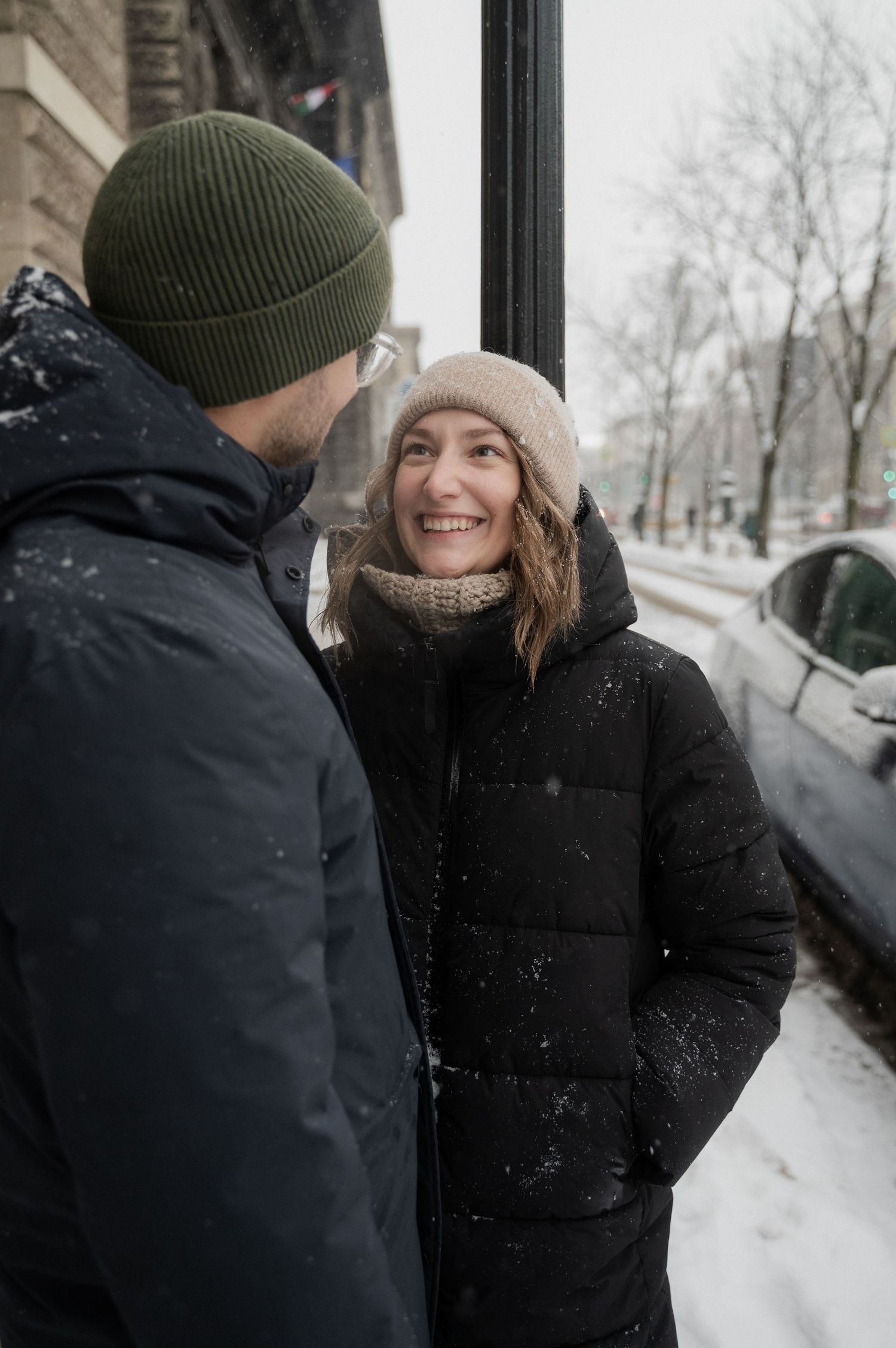 A cozy winter conversation between two people on a snowy street.