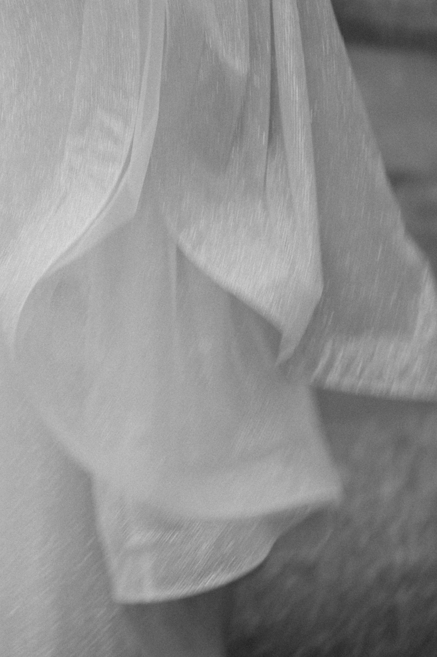 Close-up detail of flowing white fabric in soft focus.