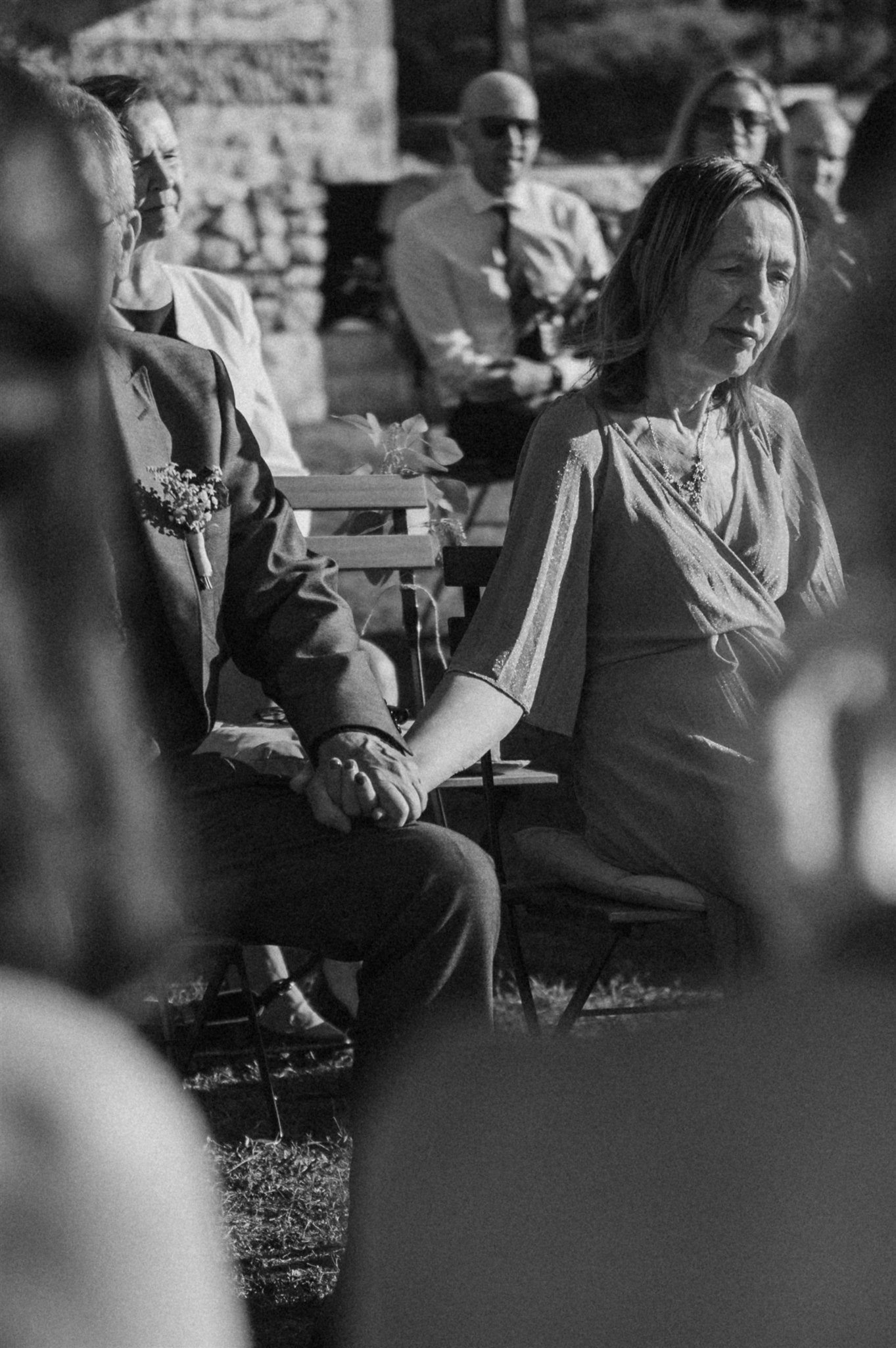 Black and white photo of guests seated during an outdoor ceremony.
