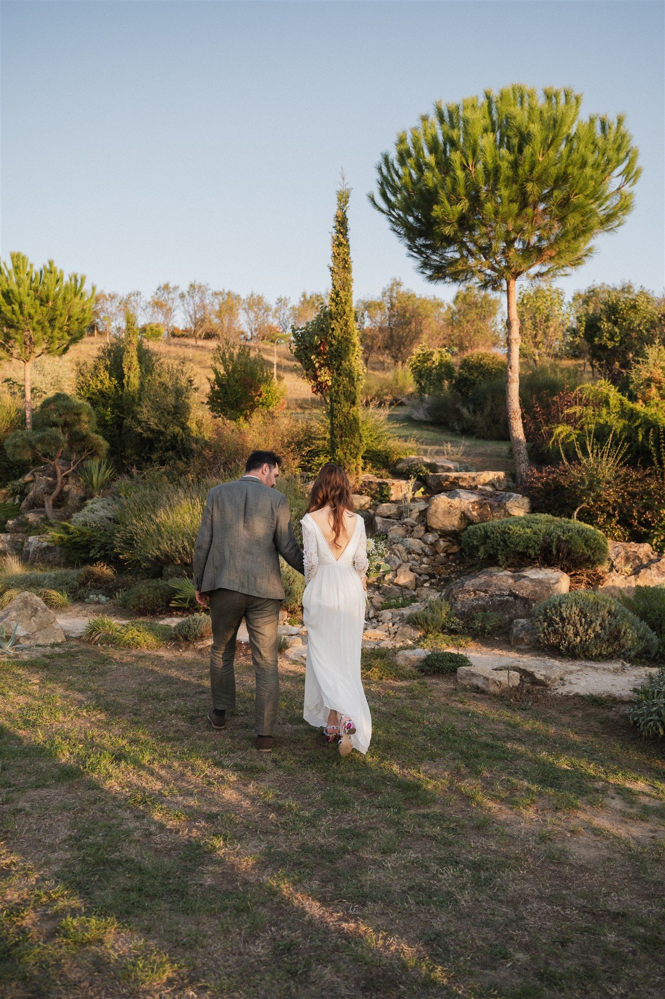 Couple walking through a garden landscape during golden hour.