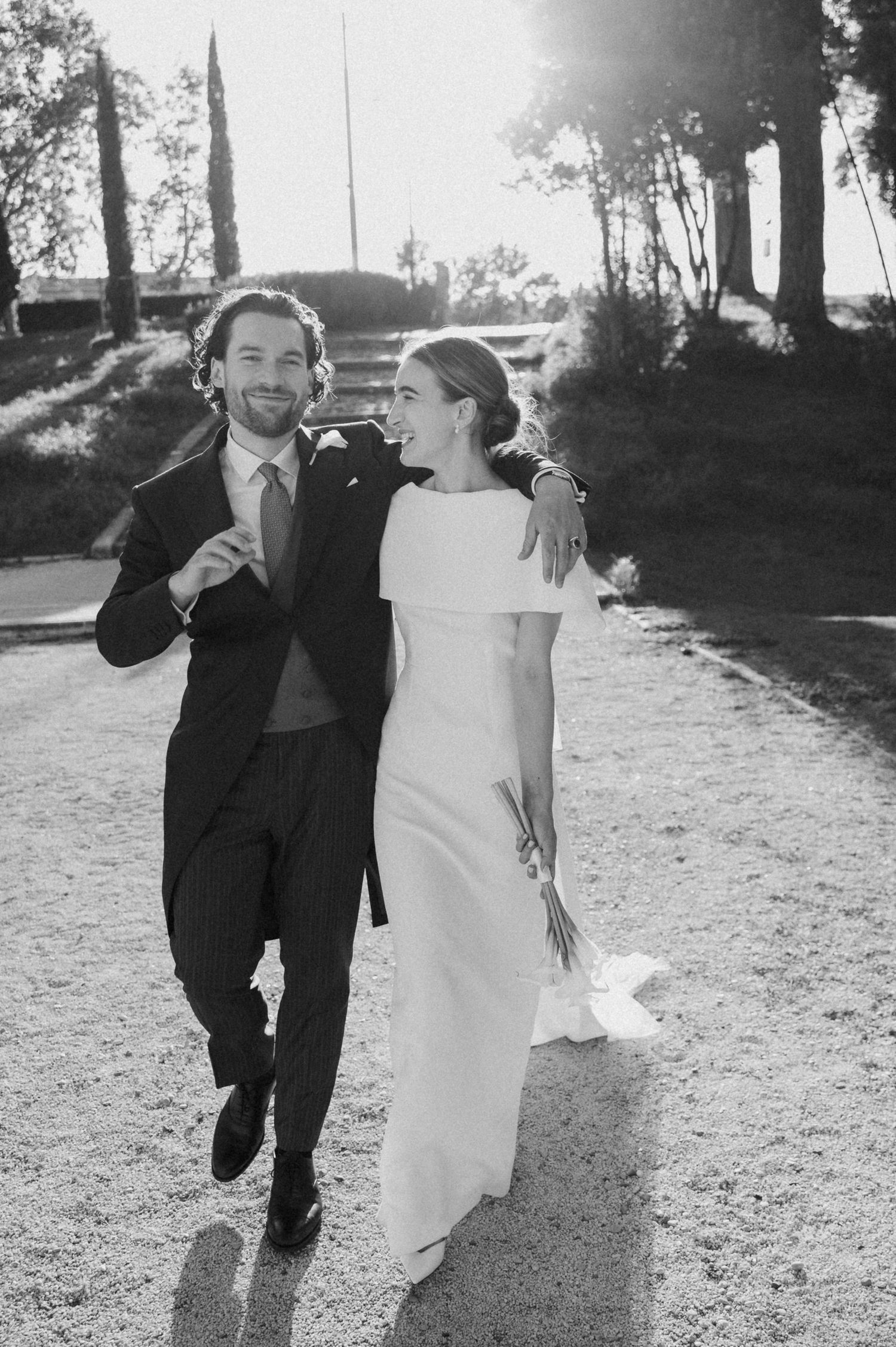 Black and white photo of a couple dancing and celebrating on their wedding day.