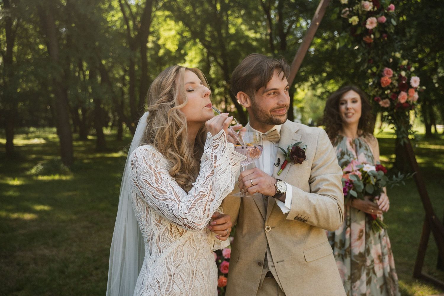 A romantic outdoor wedding ceremony in a lush garden setting with floral arrangements and natural sunlight filtering through trees.