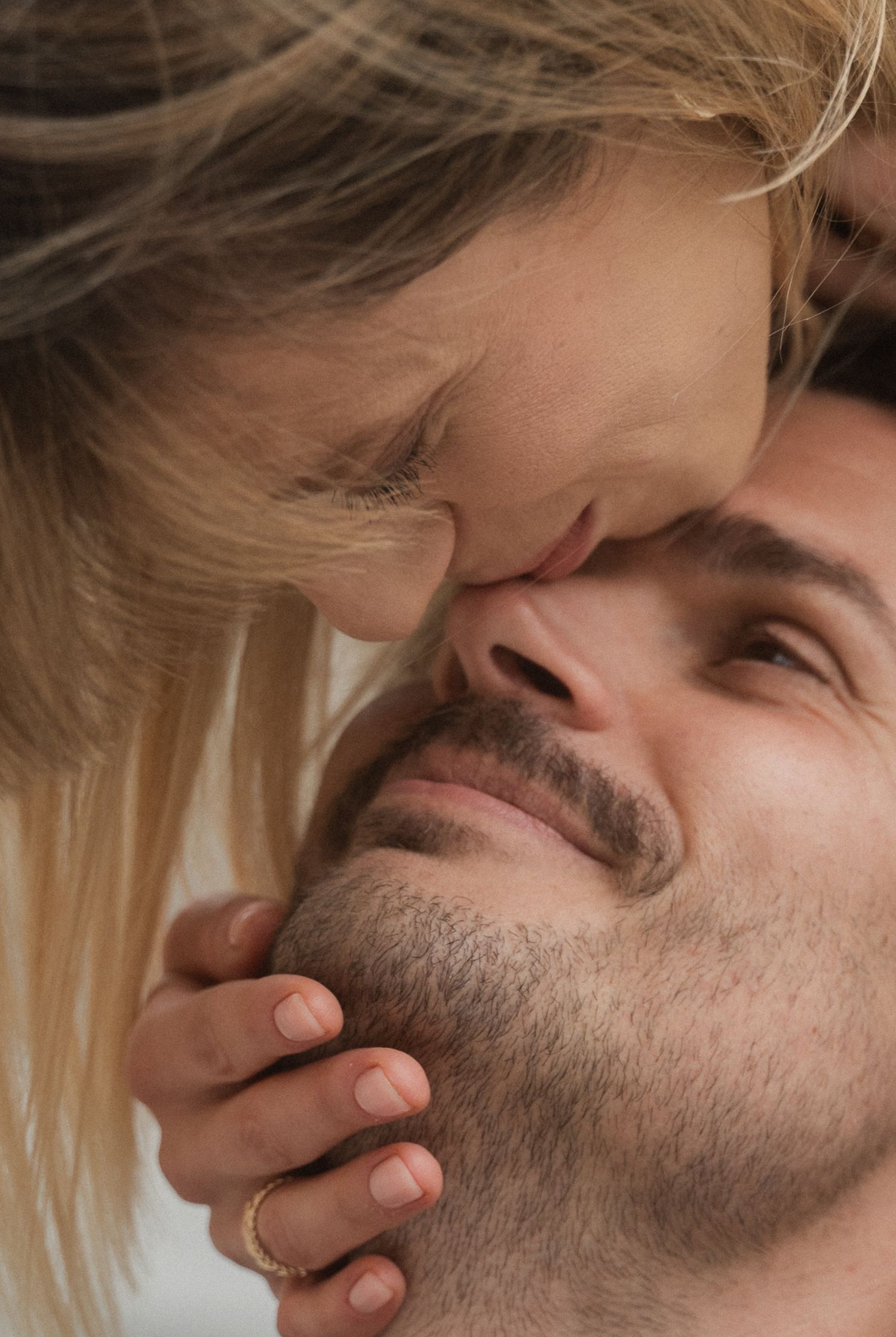 Close up series showing a tender intimate moment between two people with blonde hair and facial hair.