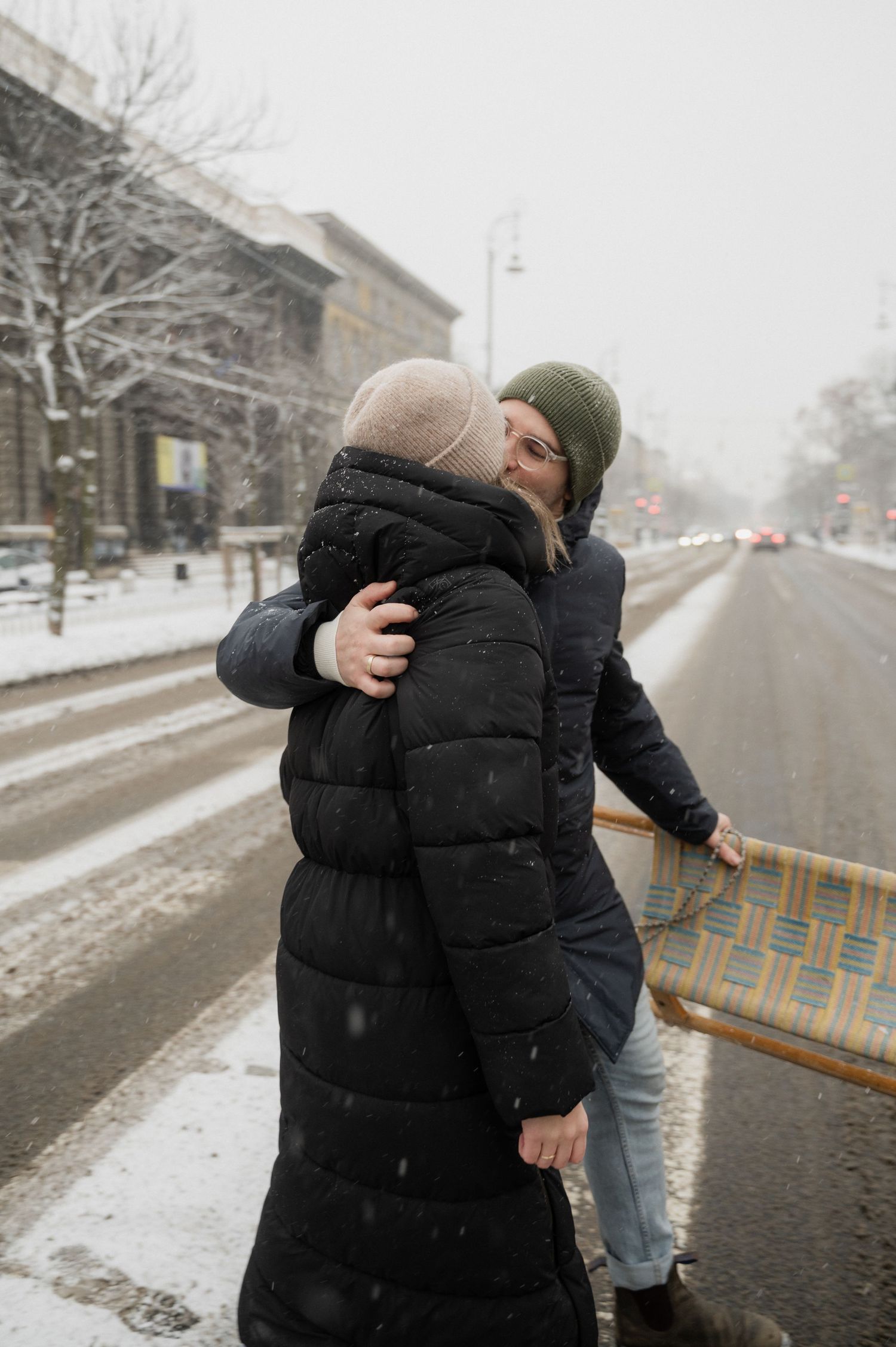 Two people sharing a moment together on a snowy winter street.