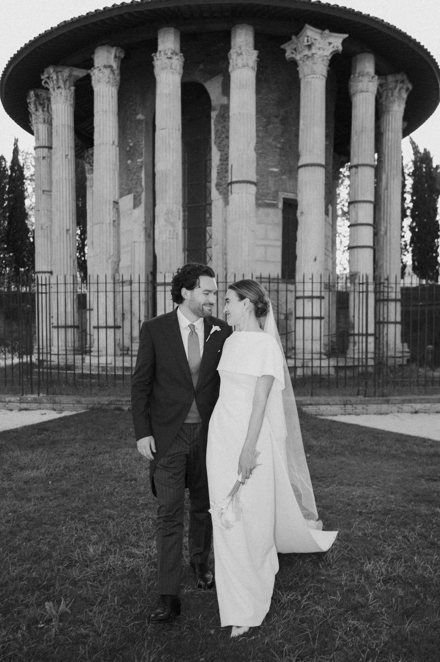 Black and white wedding portraits captured at historic temple with dramatic columns.