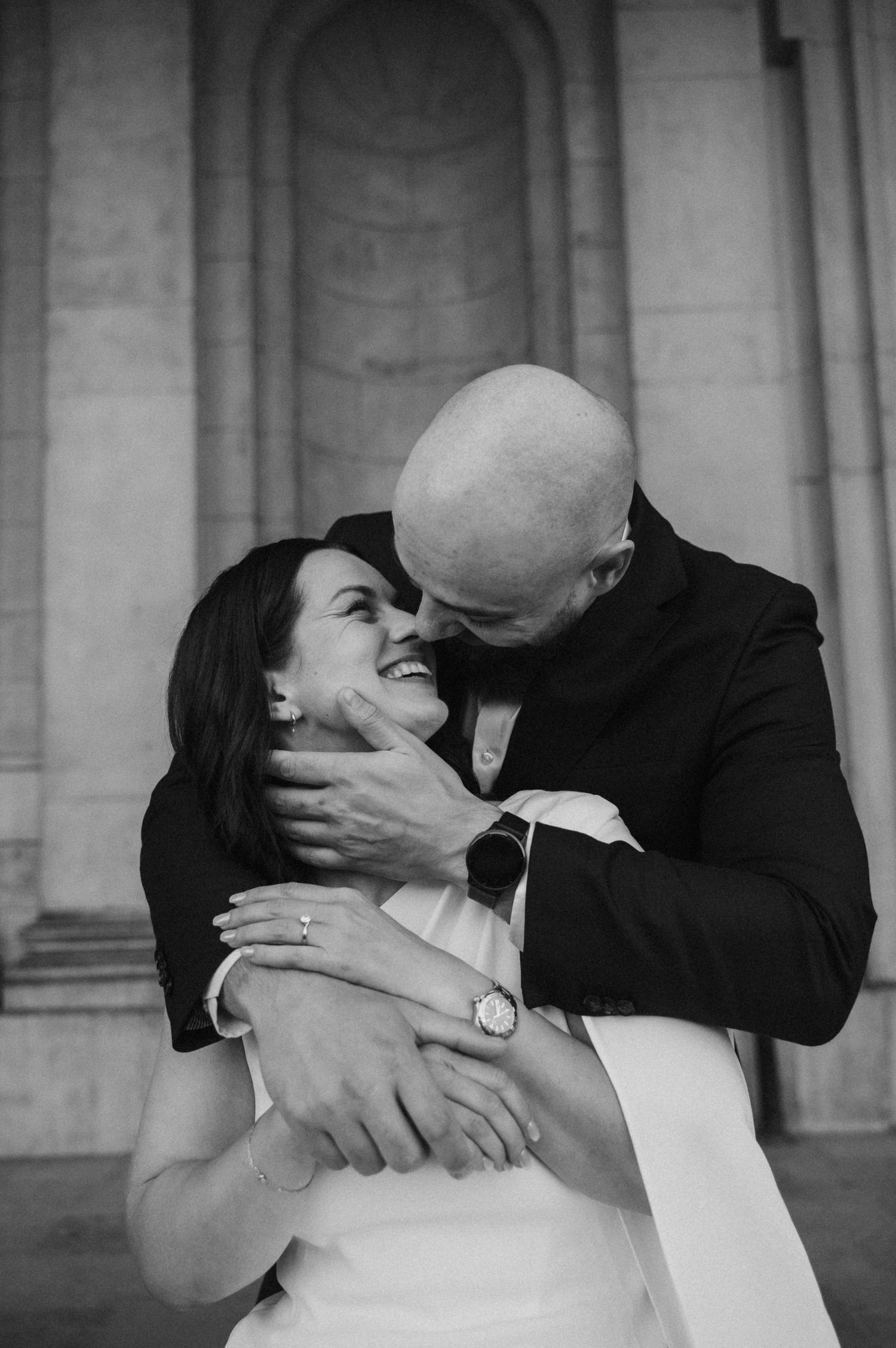 Newlyweds share intimate moments in a series of candid shots against a classical stone backdrop.