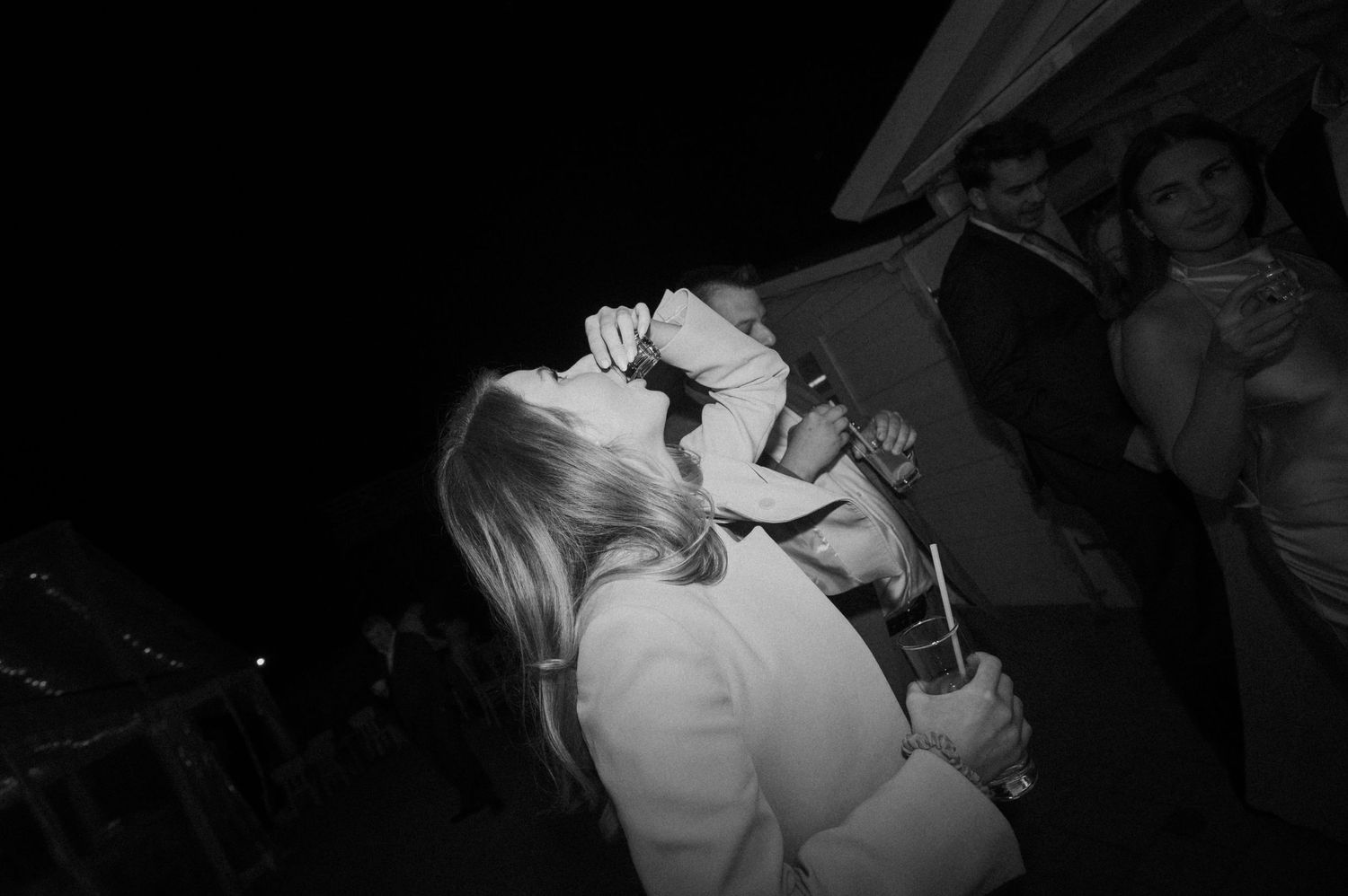 Black and white photo of couple sharing a kiss on the dance floor at a wedding reception.
