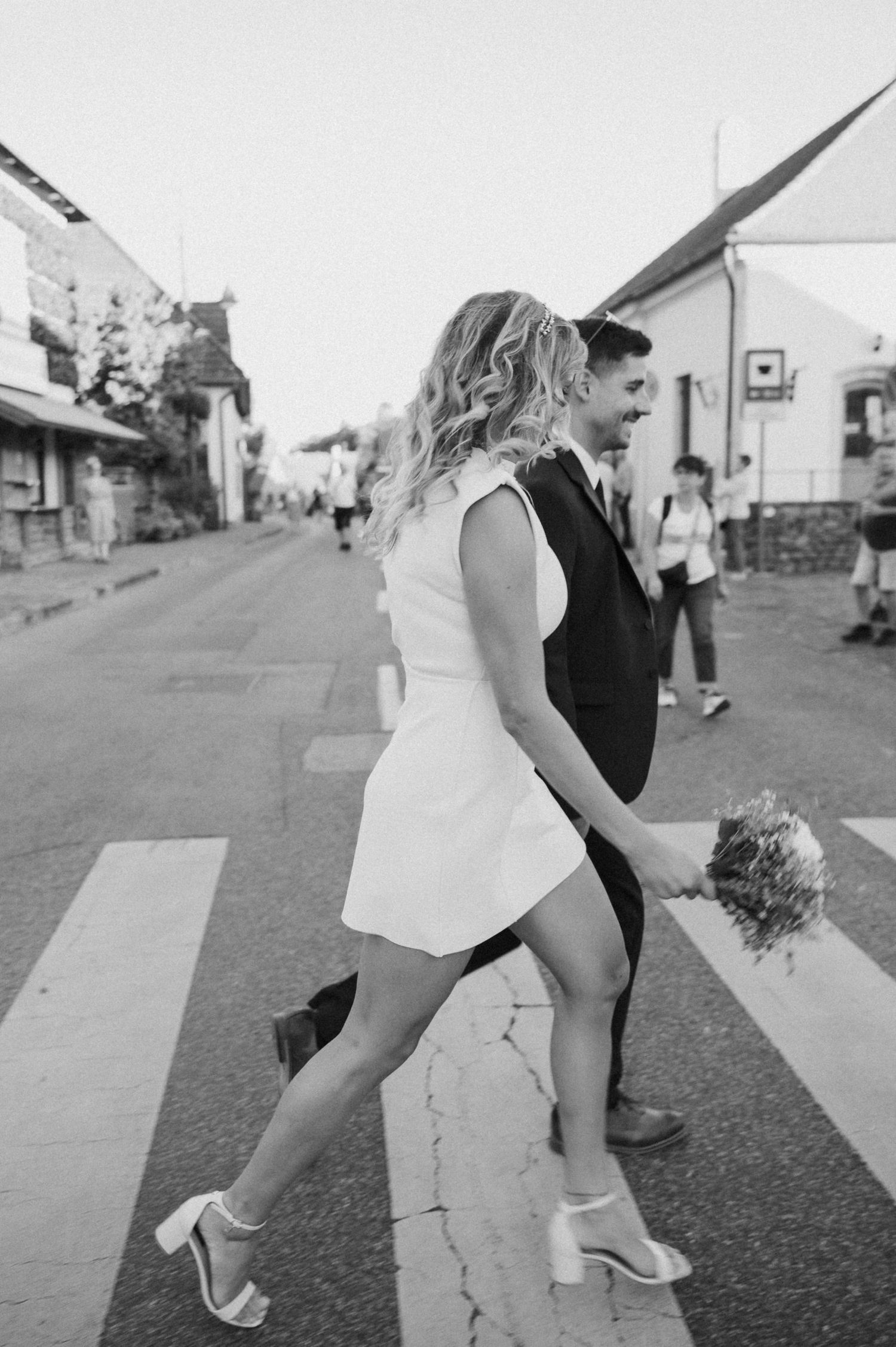 A sequence of black and white photos shows two people dancing together on a street or walkway.