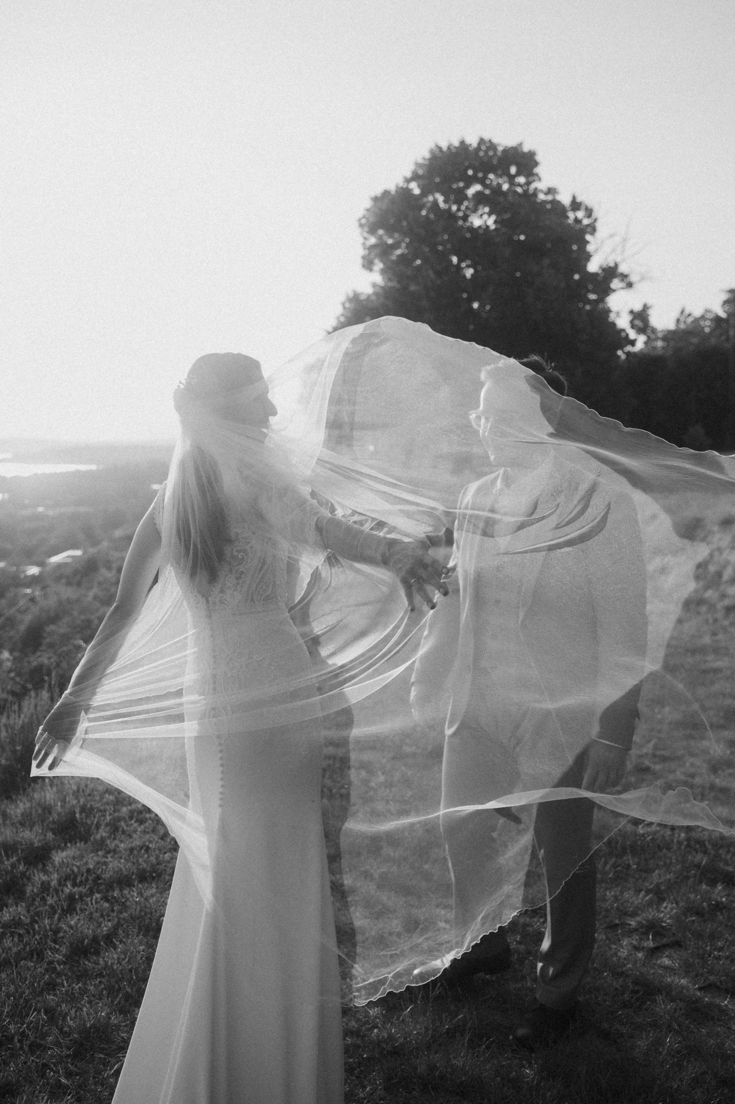 Ethereal shots of a person in white fabric moving gracefully in a field with flowing material.