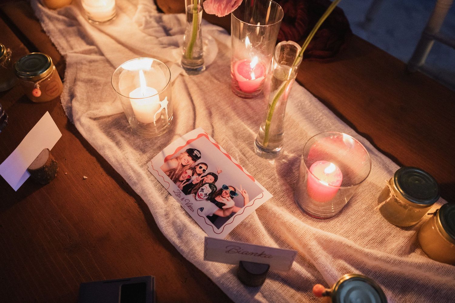 A romantic candlelit dinner table set with wine glasses, glowing candles and rustic decor creates an intimate ambiance.