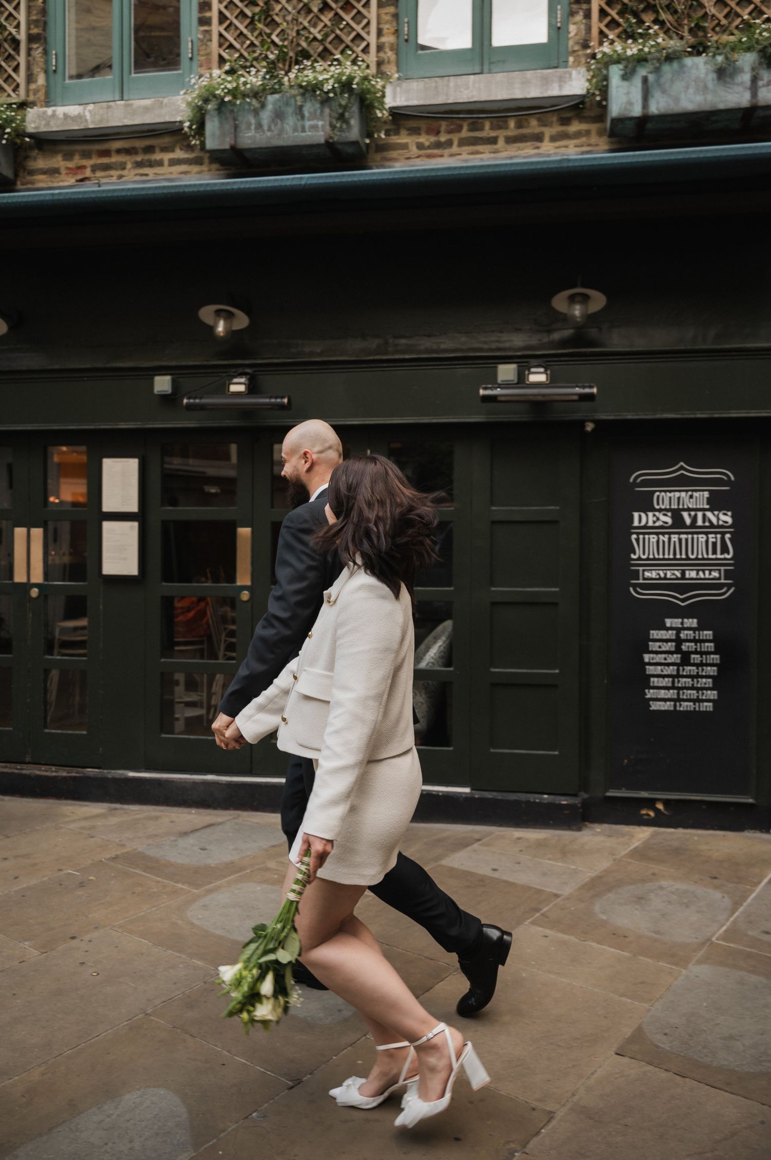 A couple performs dance moves outside a historic building entrance.