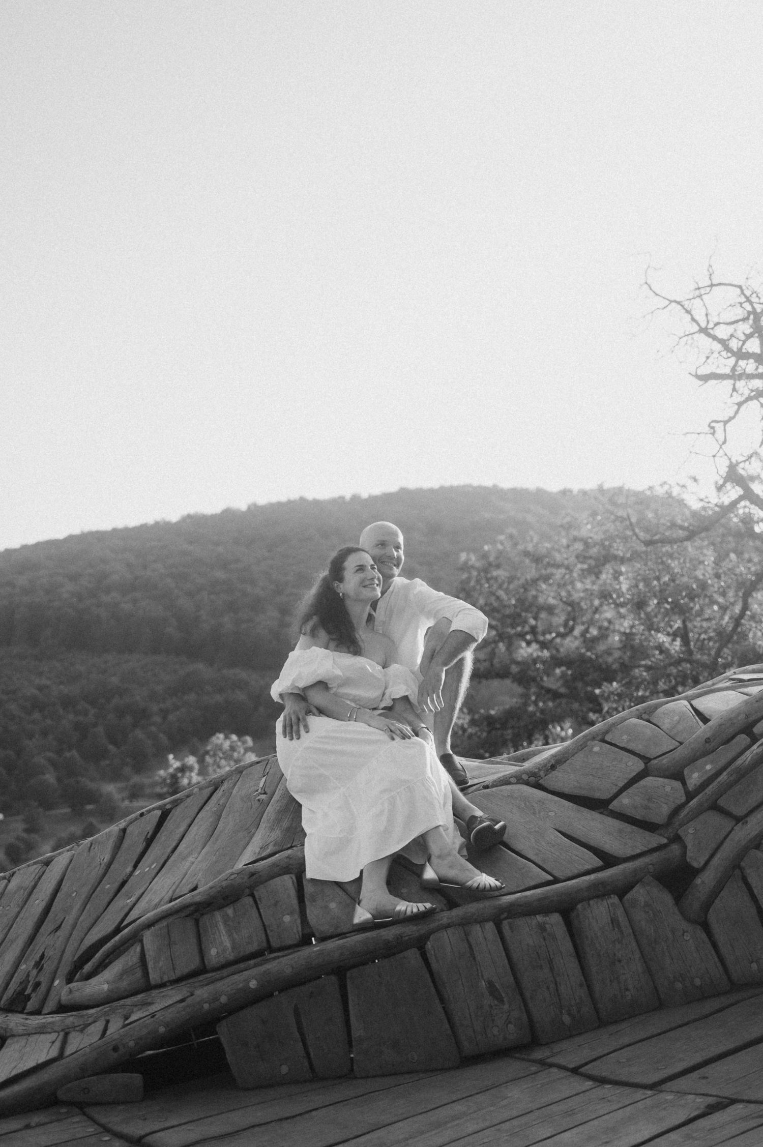 A sequence of black and white photos showing a person lying down on a textured surface against a hillside backdrop.